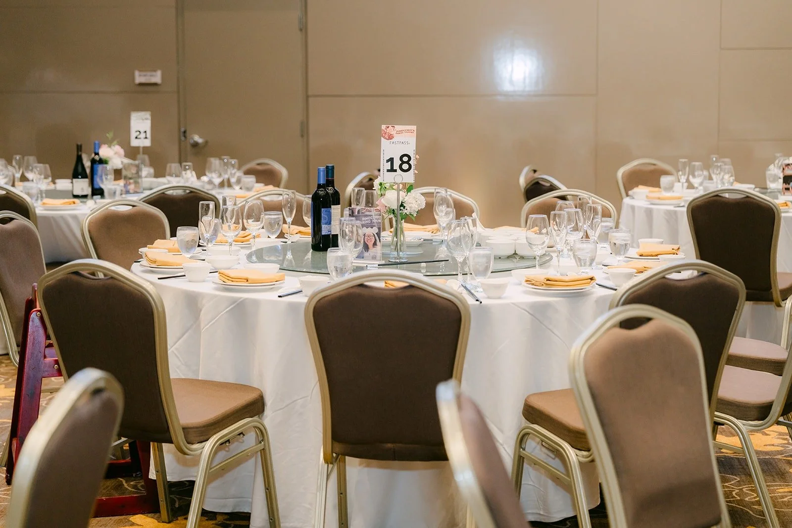 A reception table set with white linens, glassware and a numbered table card