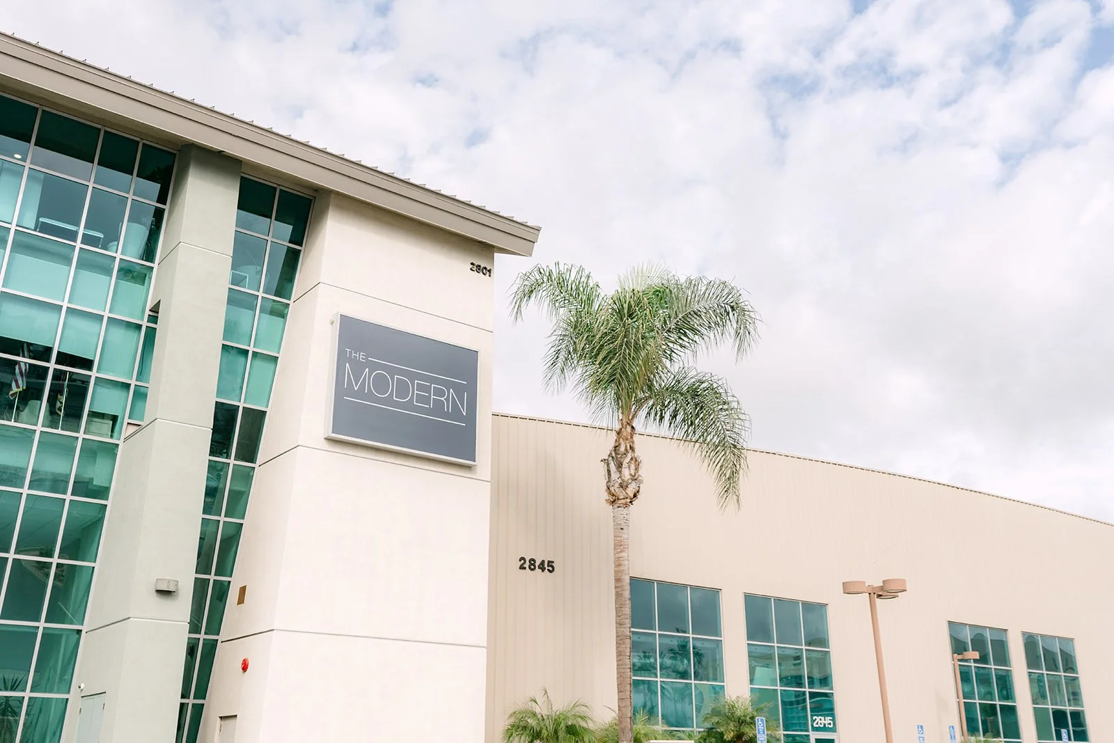 Exterior of The Modern wedding venue in Long Beach with palm trees and blue sky