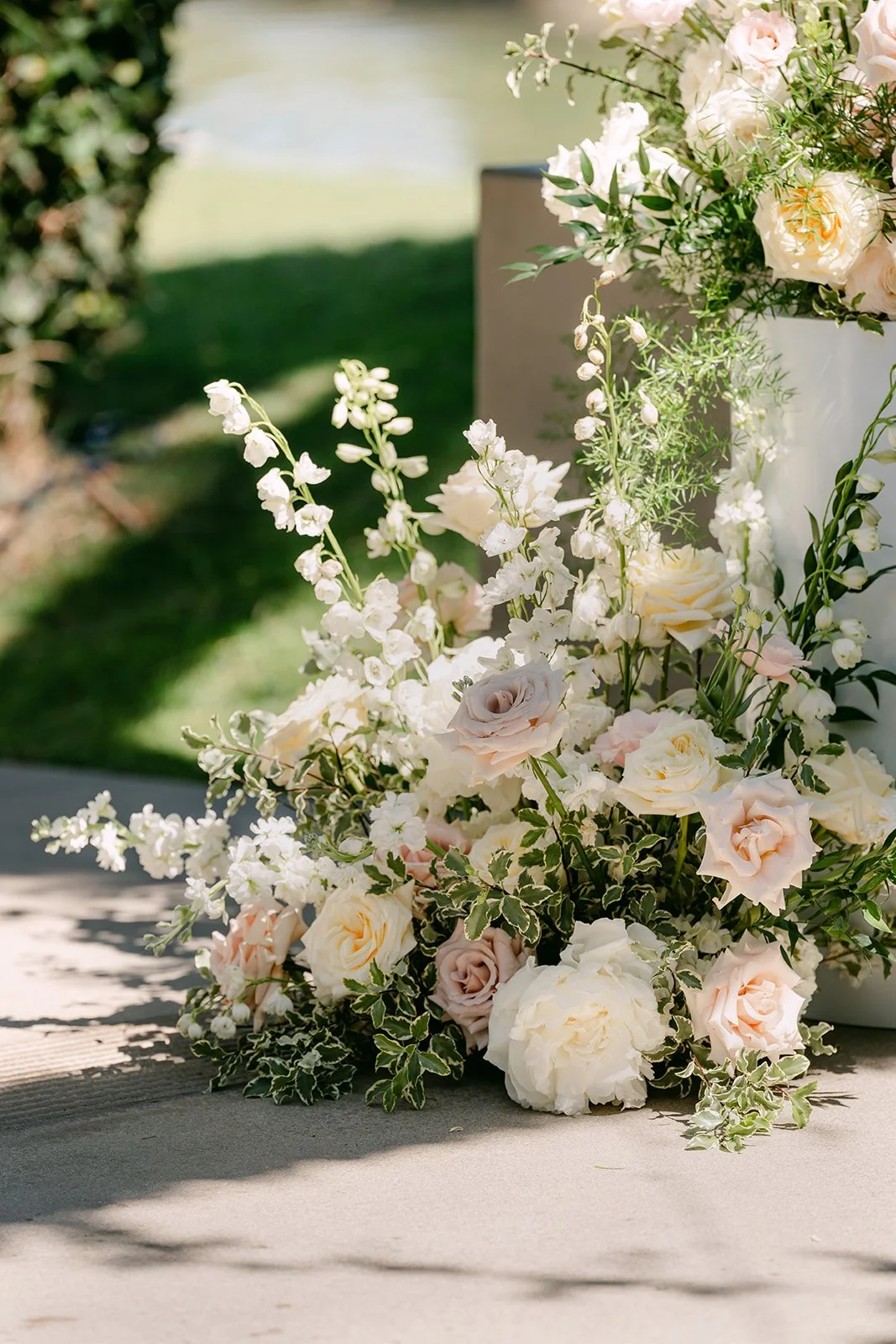Blush and cream florals lining the ceremony aisle.