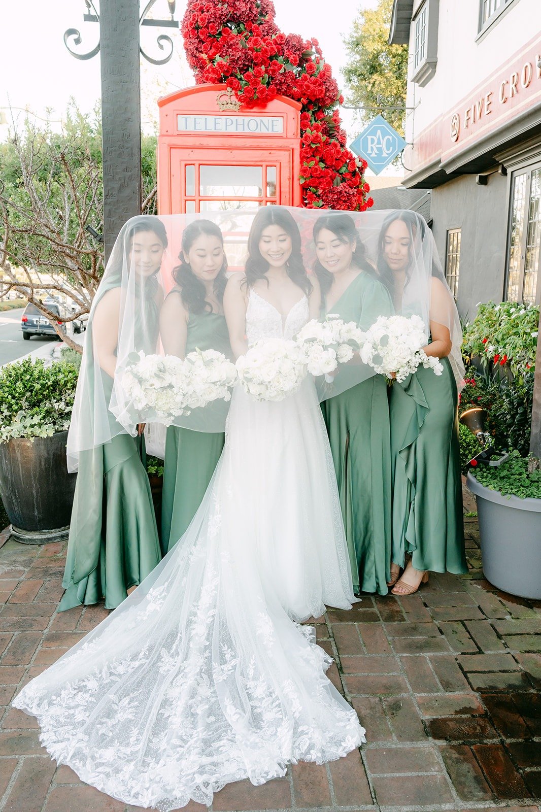 Valerie and her bridesmaids laughing under her veil