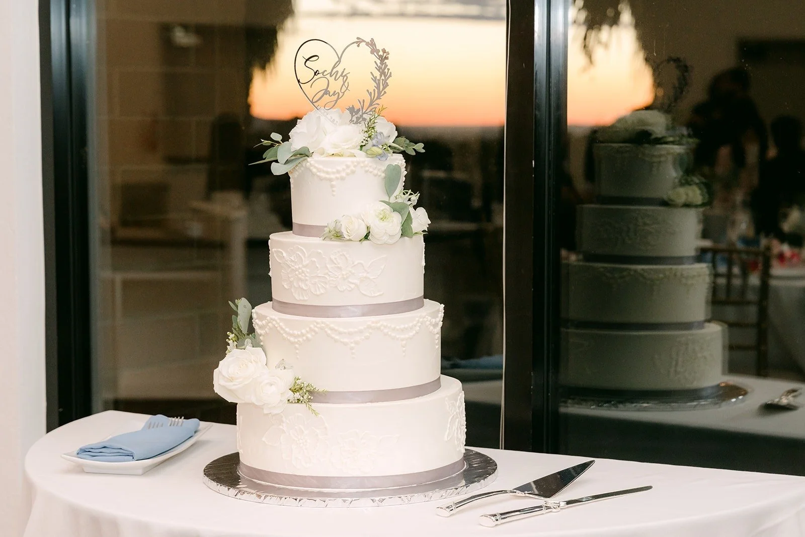 The white tiered wedding cake topped with florals