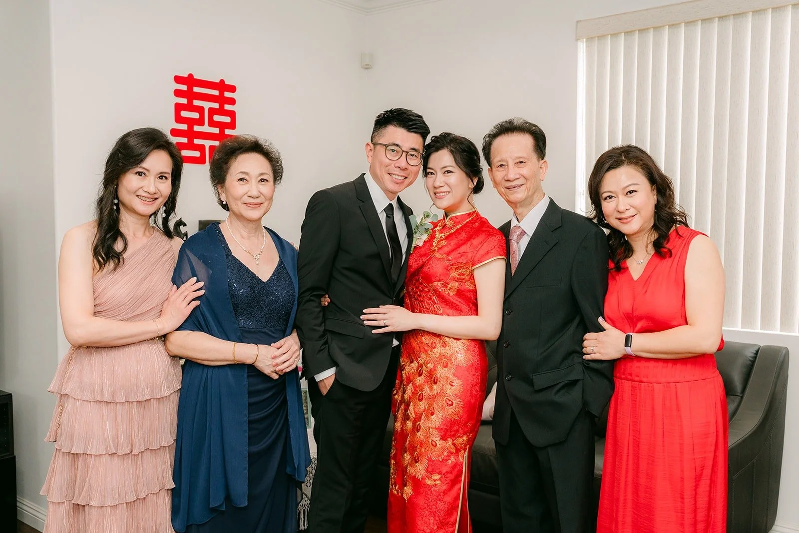 Eunice and Eric with family members in front of the double happiness sign