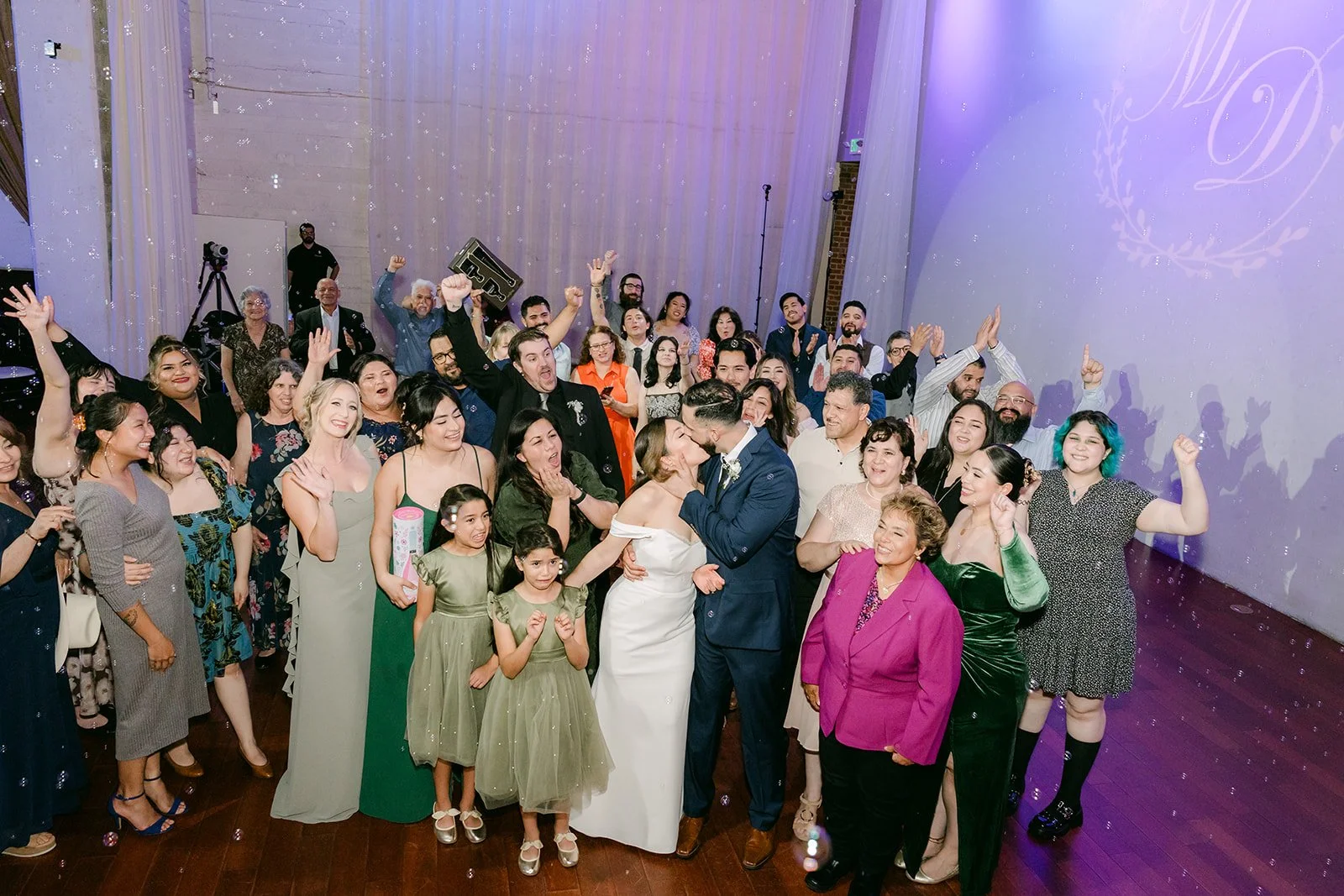 The whole dance floor packed with guests under the projected monogram
