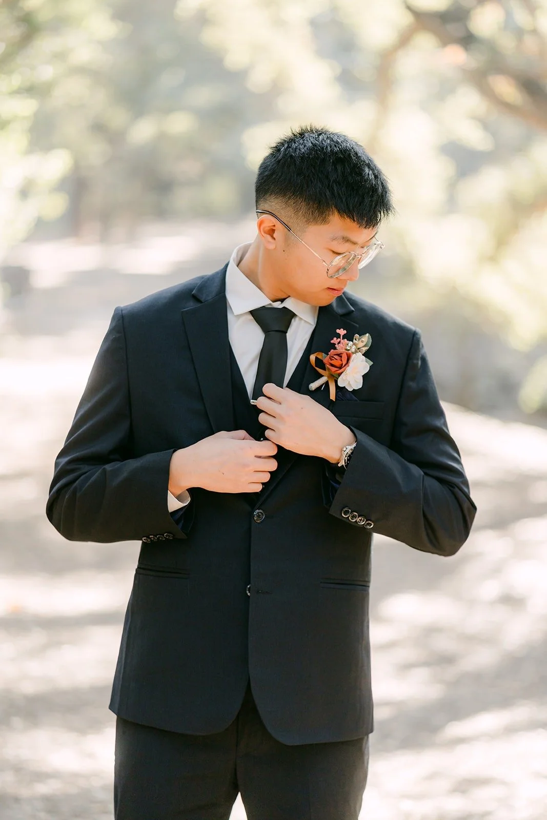 Robert buttons his jacket, a boutonniere on his lapel