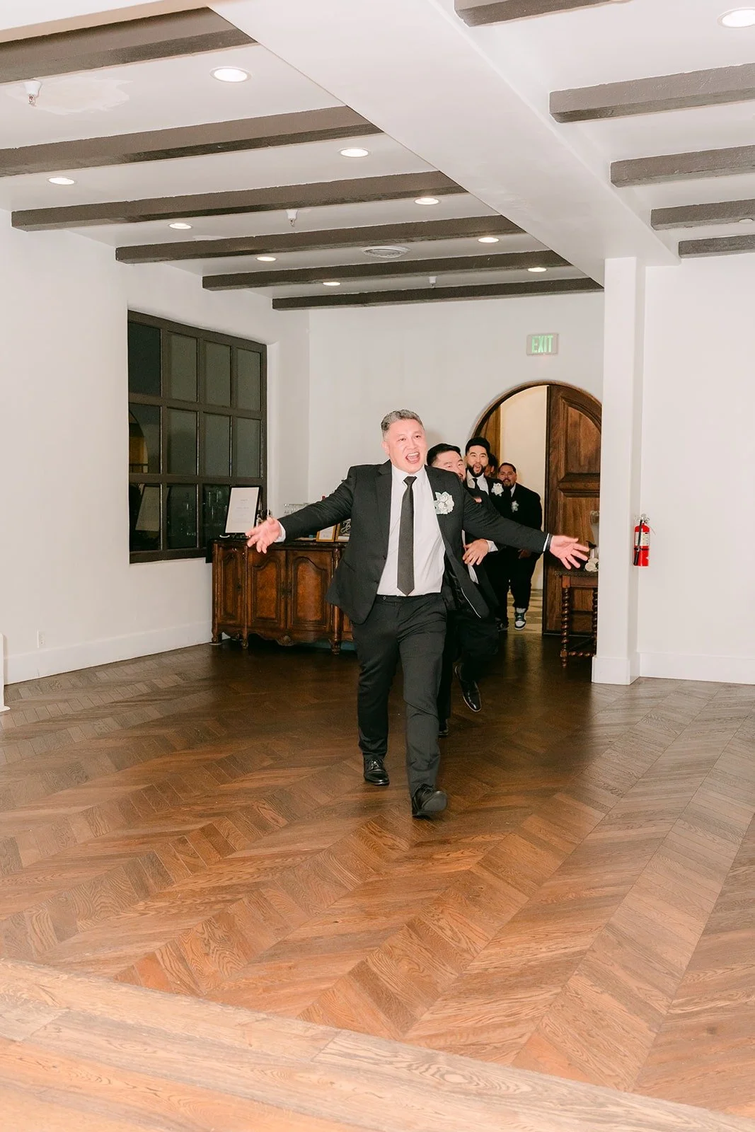 A groomsman dancing in during the grand entrance