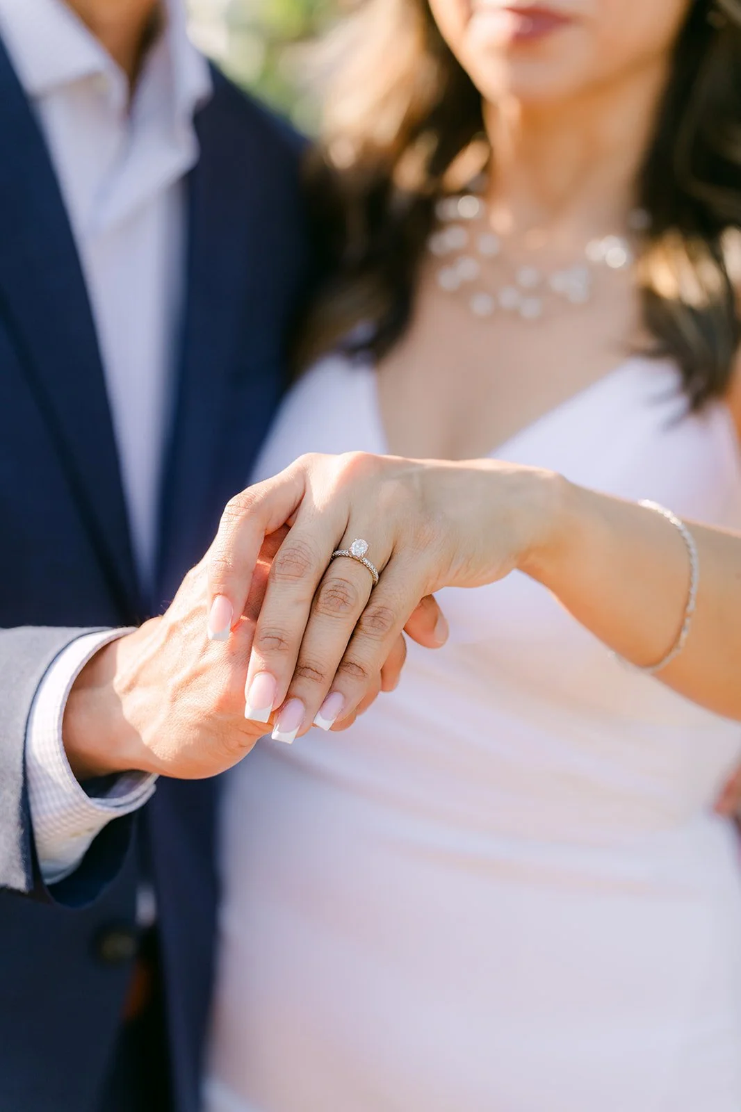 Close-up of Francesca's engagement ring as she holds Daniel's hand, photographed by One and Only Production.