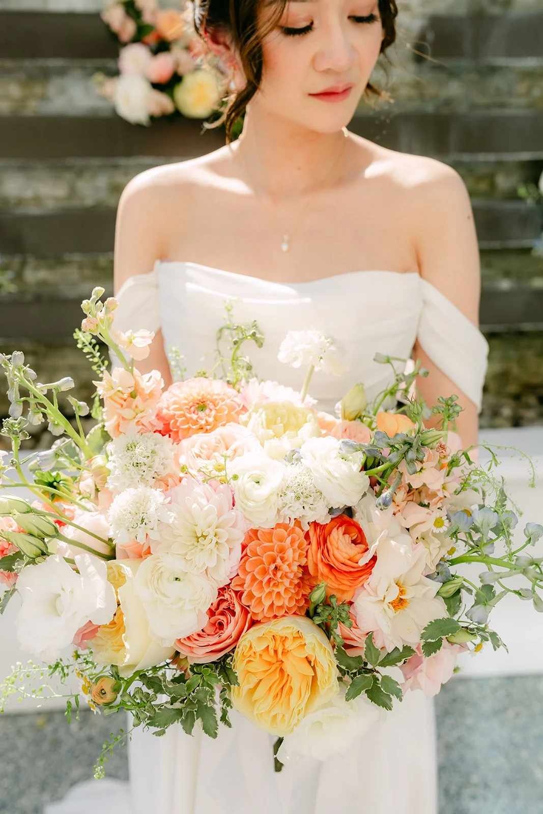 Amanda holding her peach, white and orange bouquet.