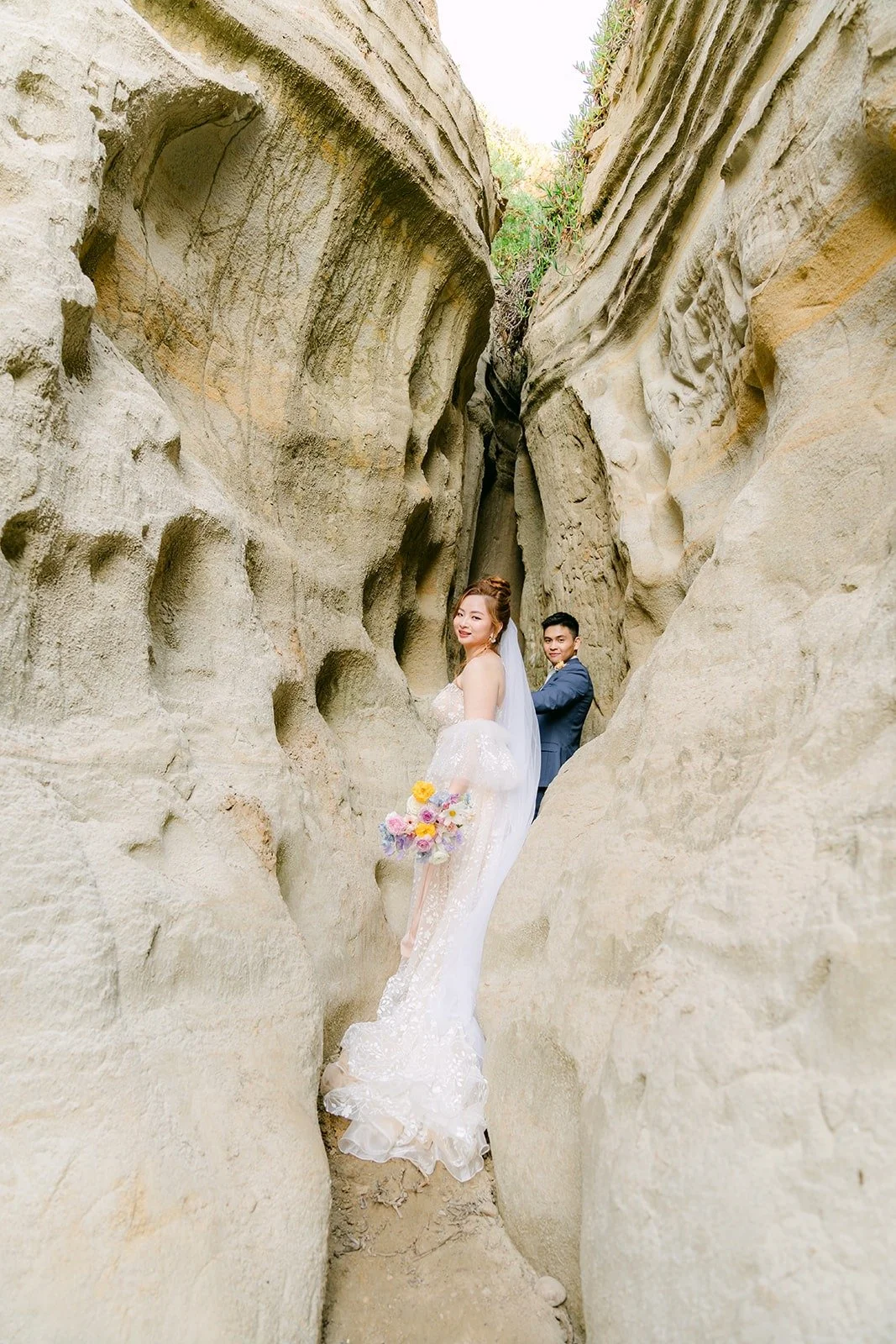 Joanna and Jerrick tucked into a narrow sandstone canyon near the beach