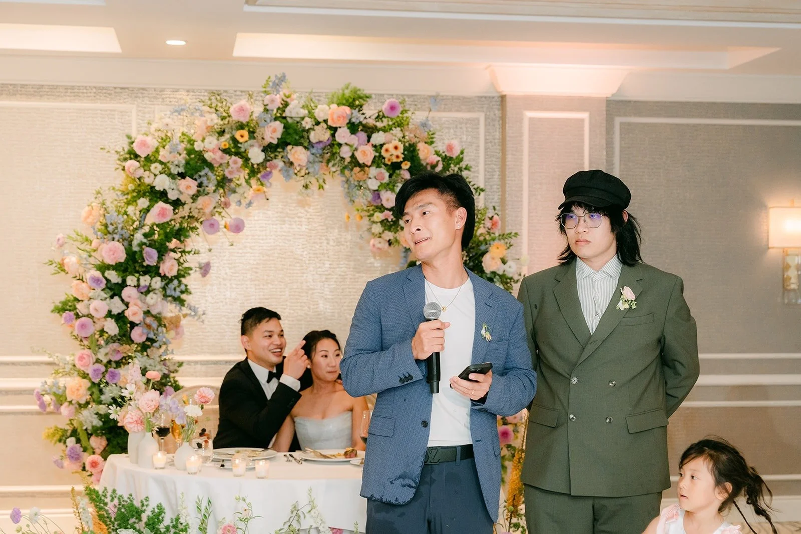 Two friends of Mario giving a speech in front of the sweetheart table