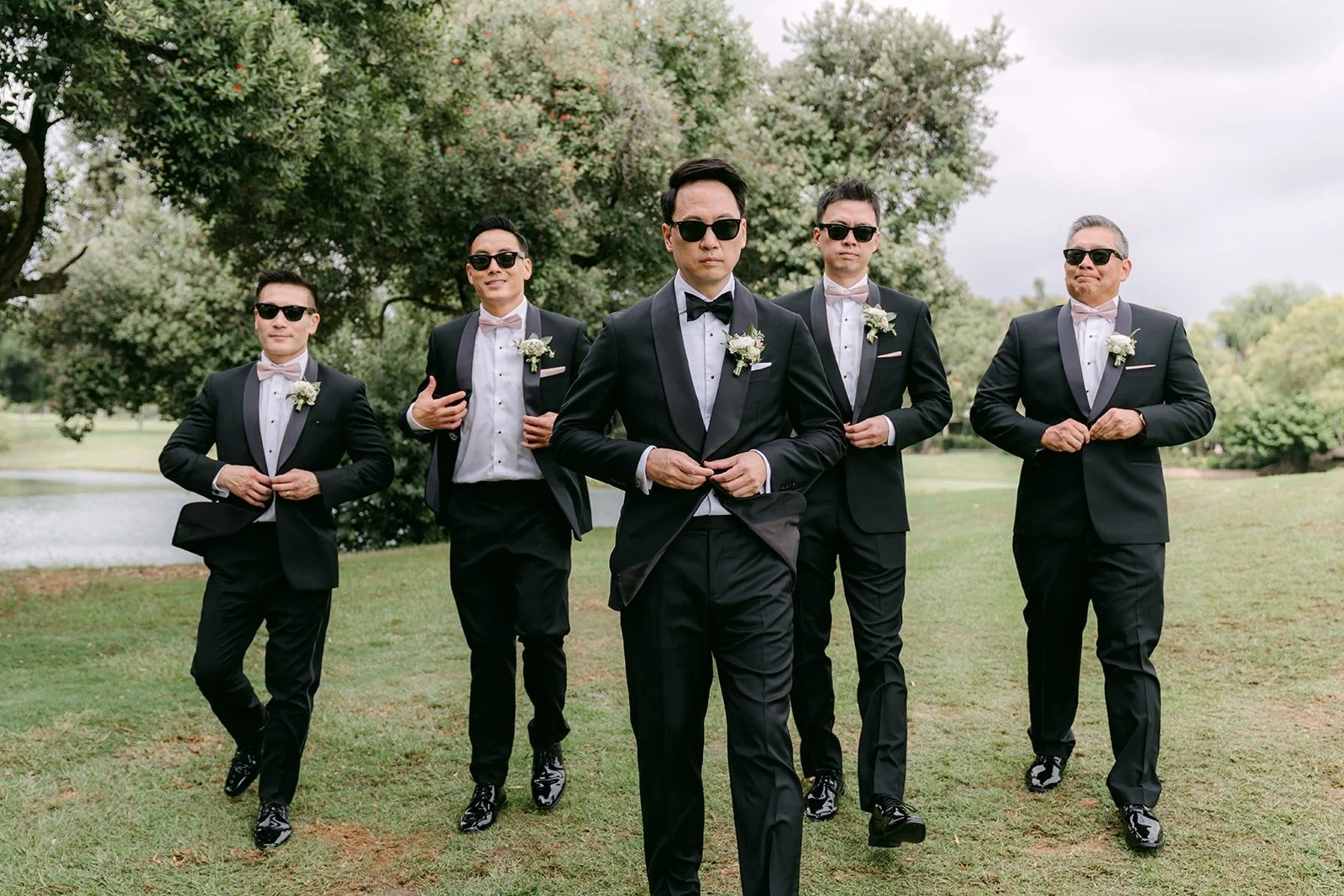 William and his groomsmen in black tuxedos and sunglasses on the fairway