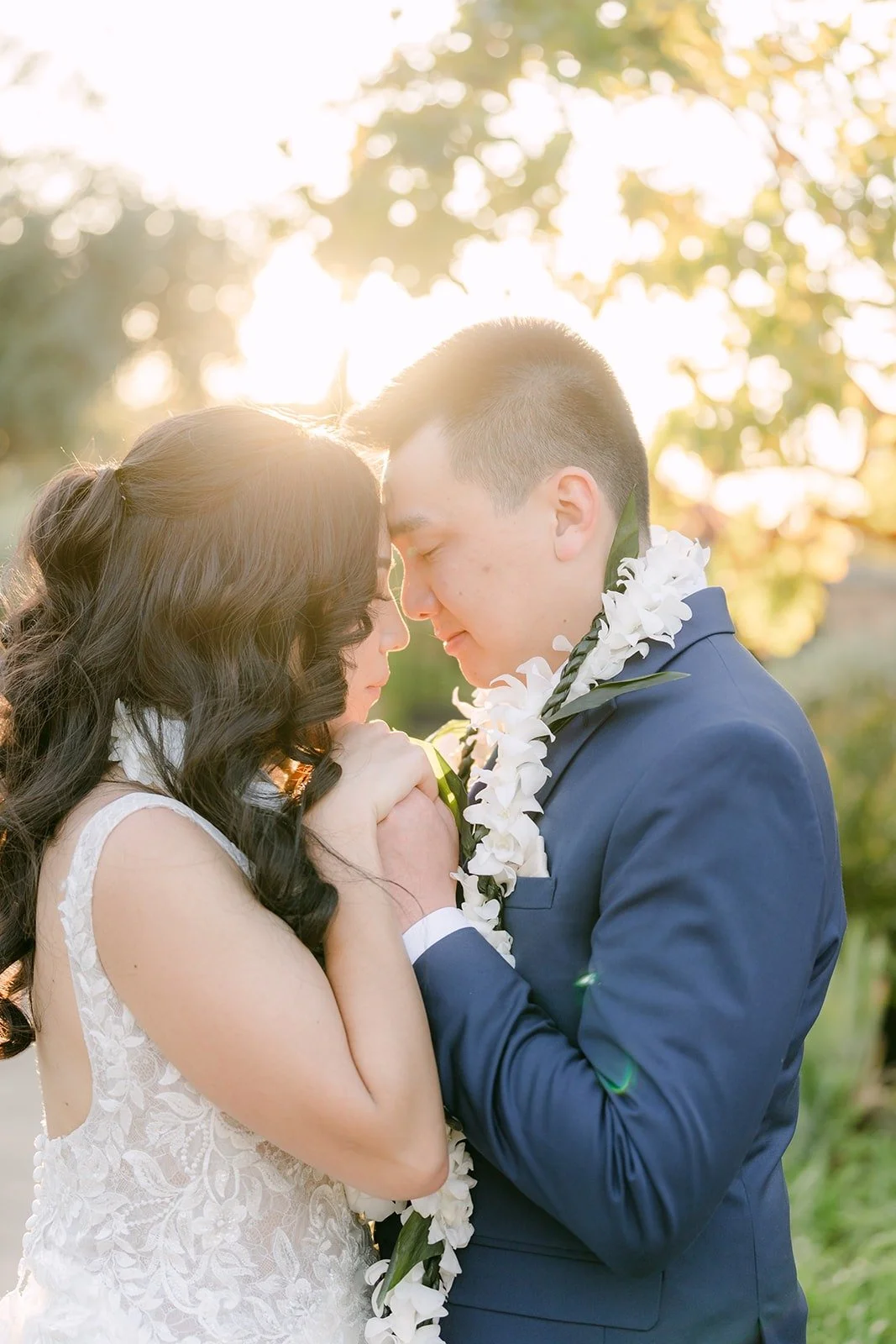 Kelli and Alex touching foreheads as the sun sets behind them