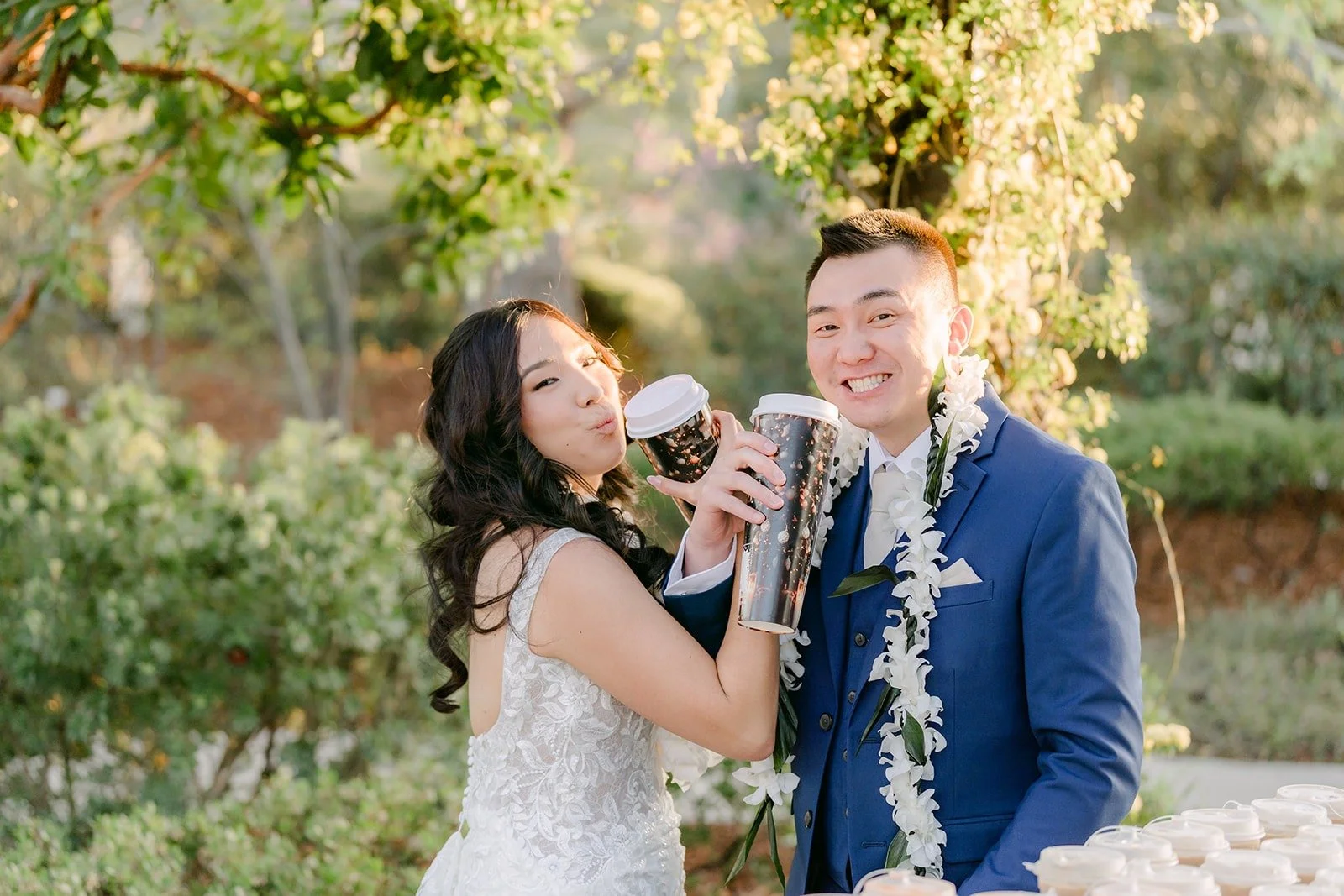 Kelli and Alex toasting with their boba drinks on the lawn