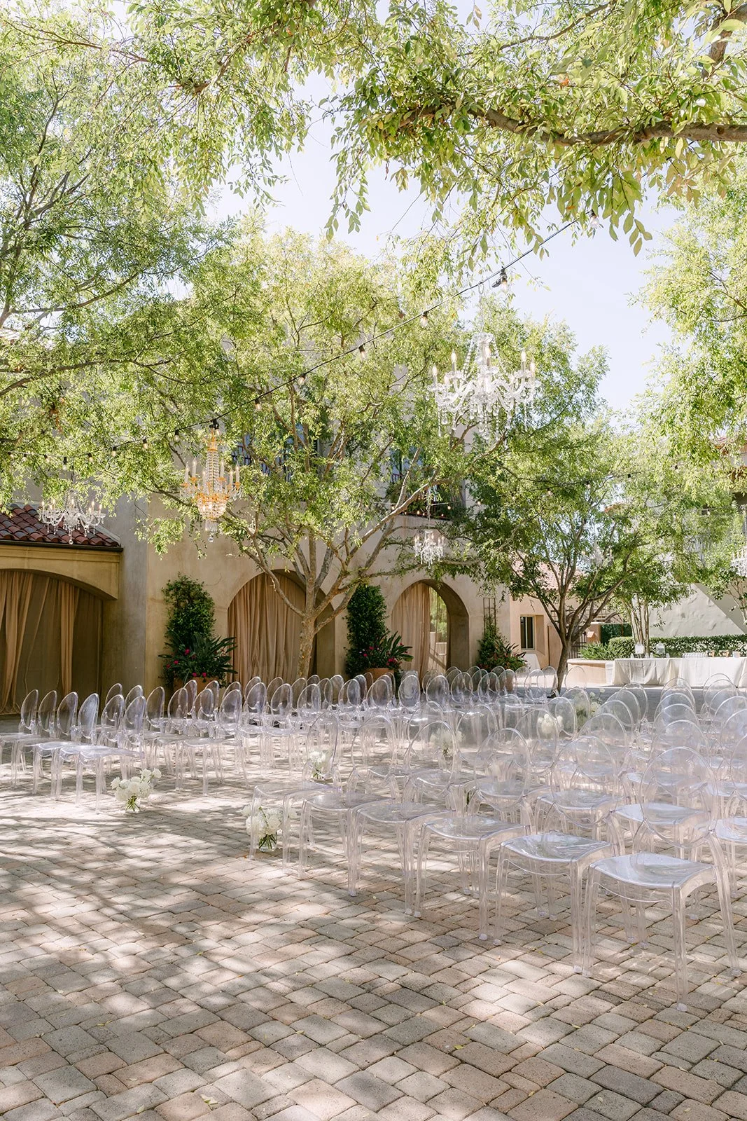Ceremony chairs set under the trees in the Serra Plaza courtyard