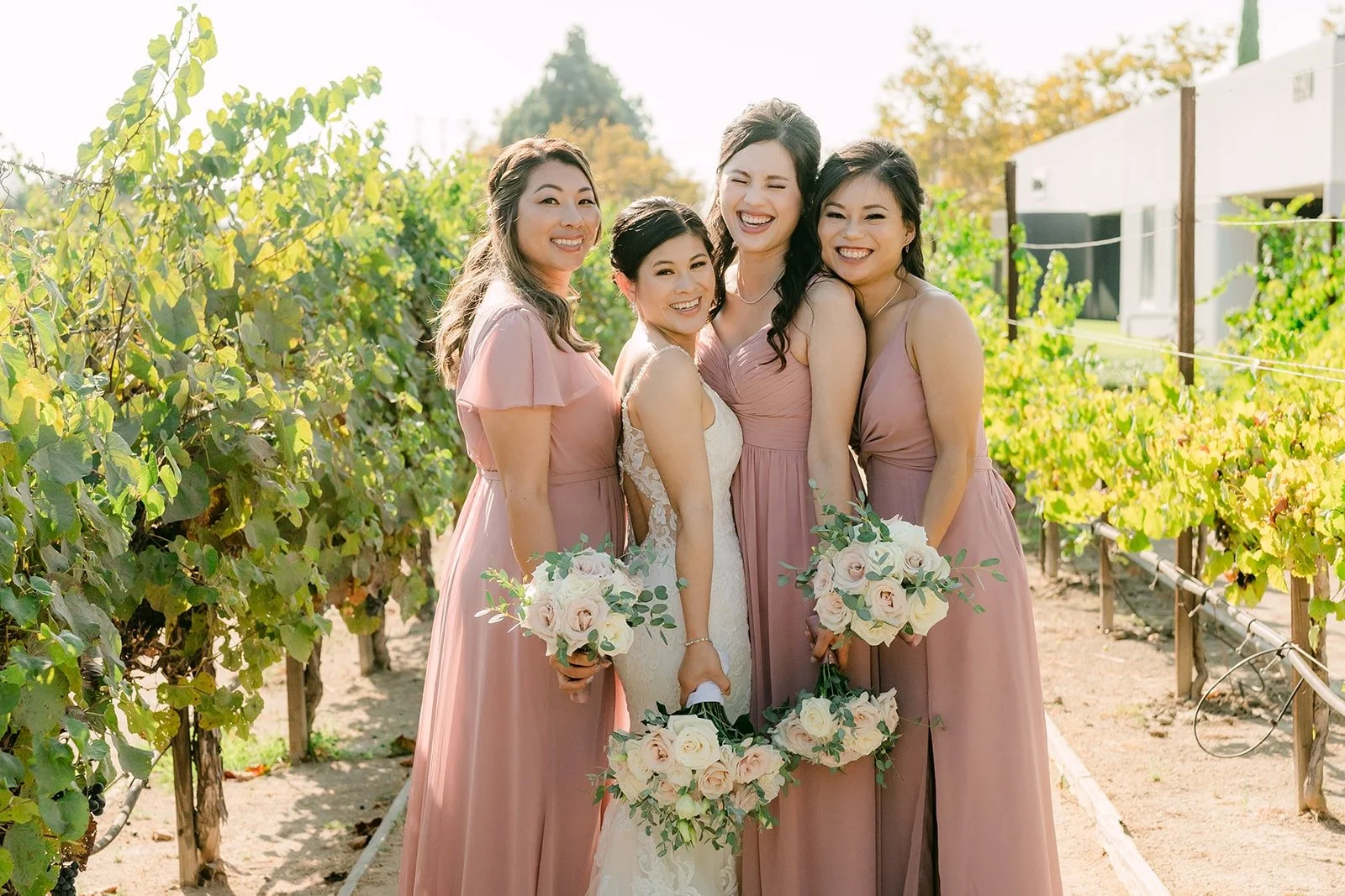 Bridesmaids laughing with Xuemin among the vines