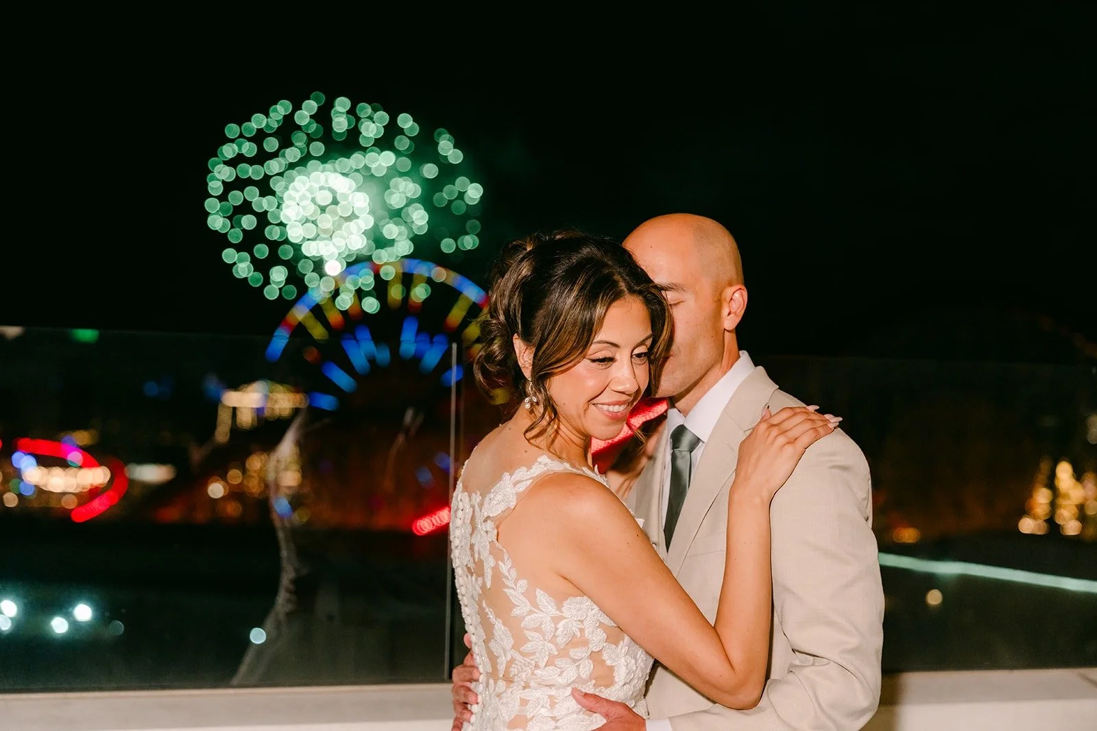 Francesca smiles in Daniel's arms as green fireworks burst behind them