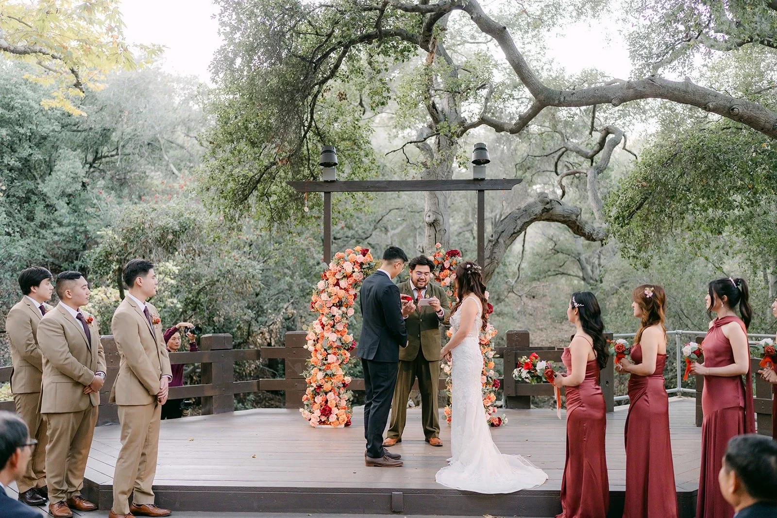 Shayna and Robert at the floral arch with their wedding party on either side