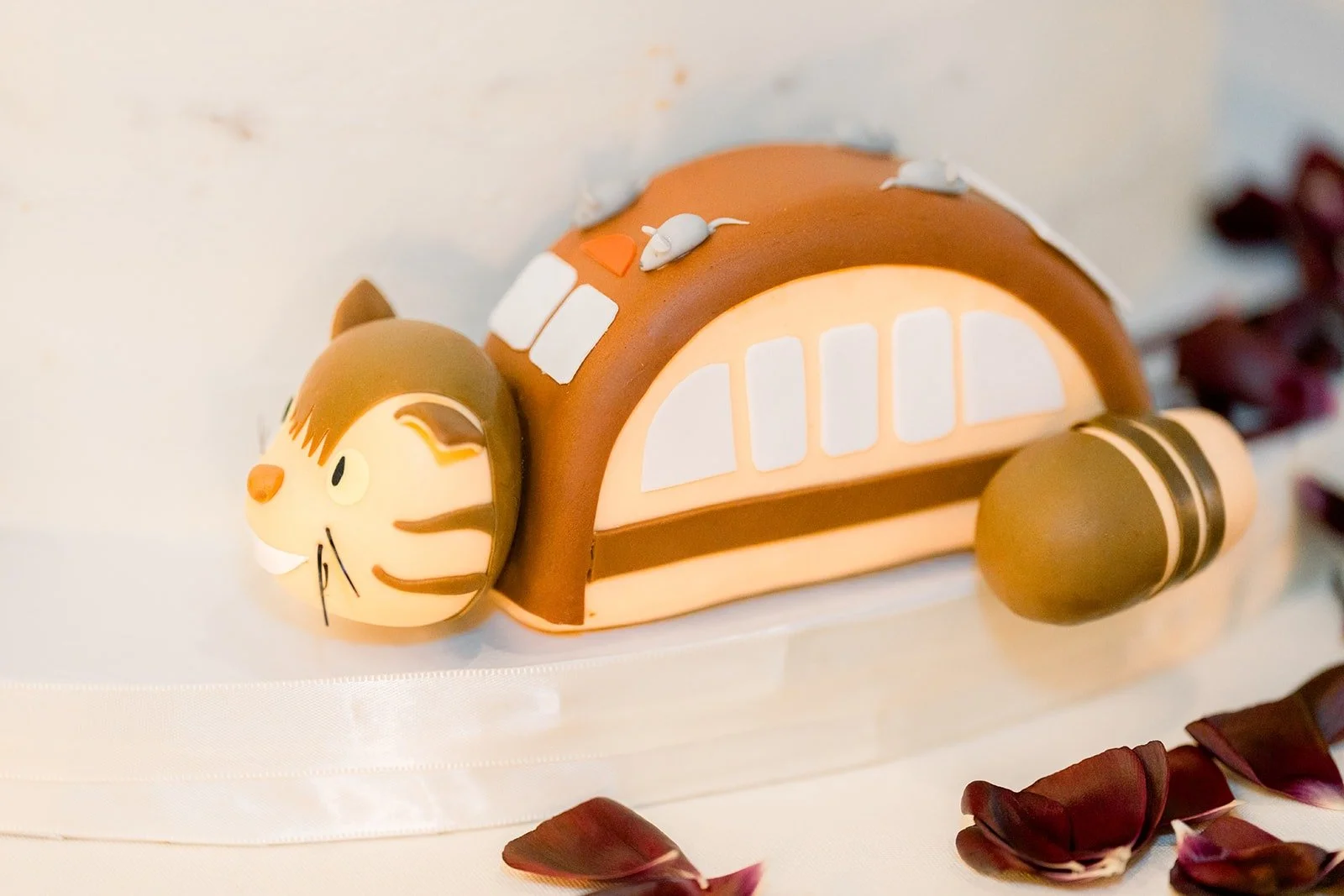 A cat bus figure on the wedding cake