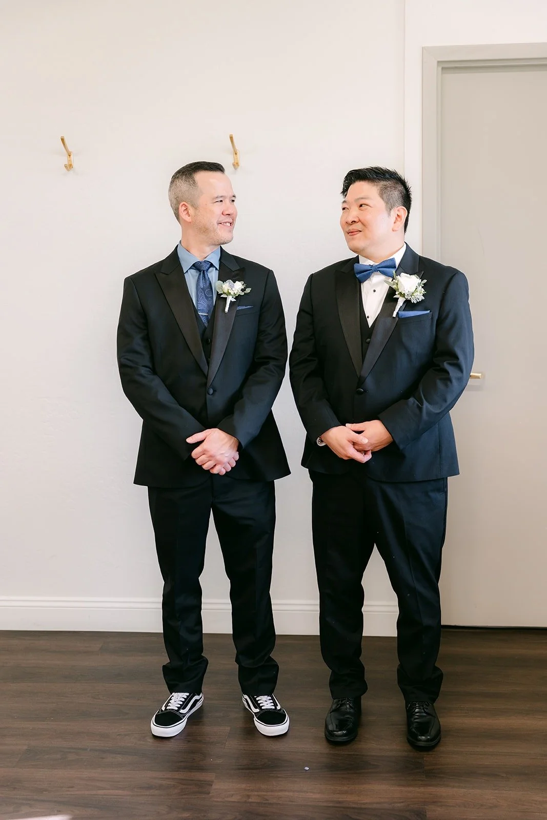 Jay and a groomsman in black tuxedos with blue bow ties