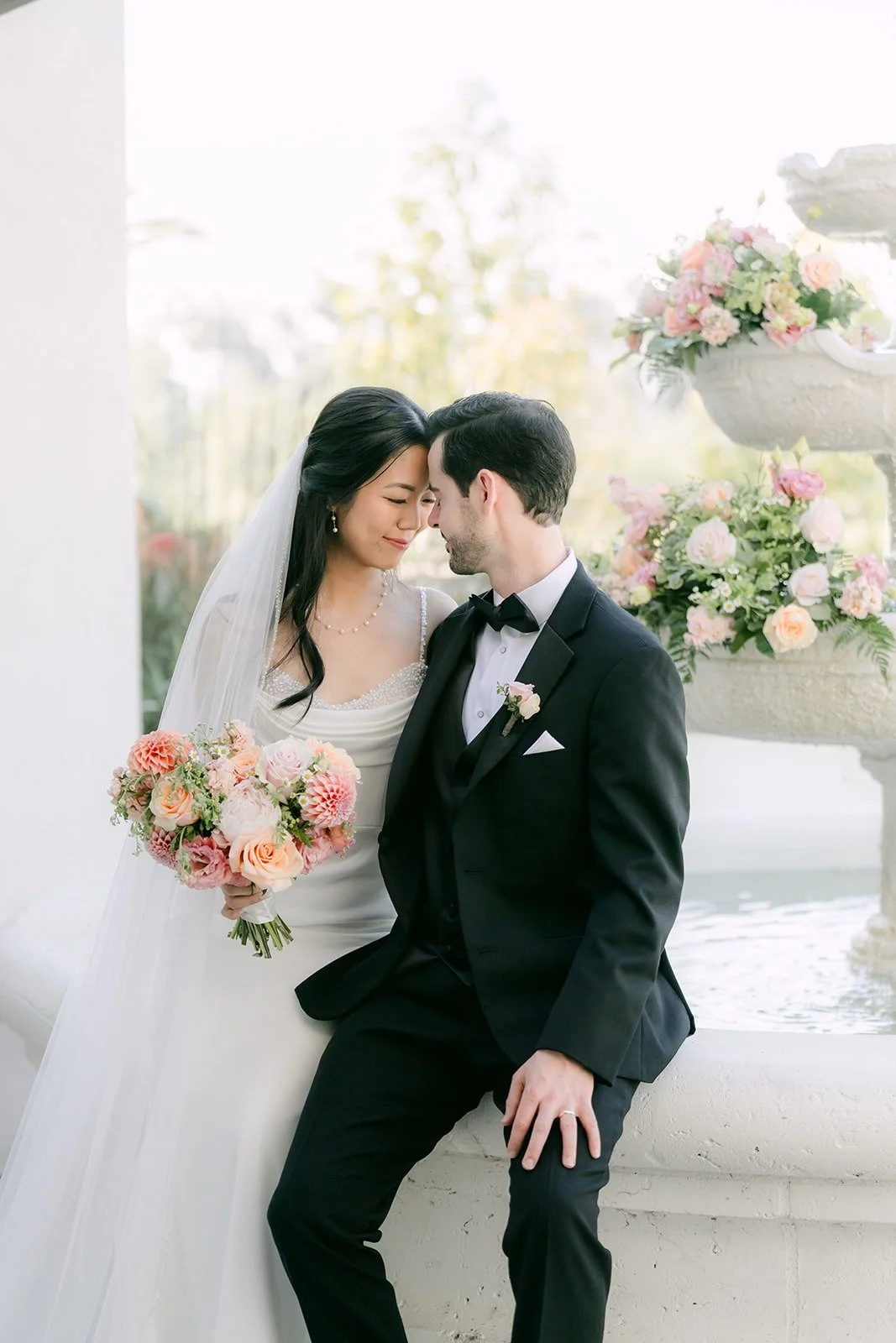 Stephanie and Kevin resting their foreheads together beside the fountain