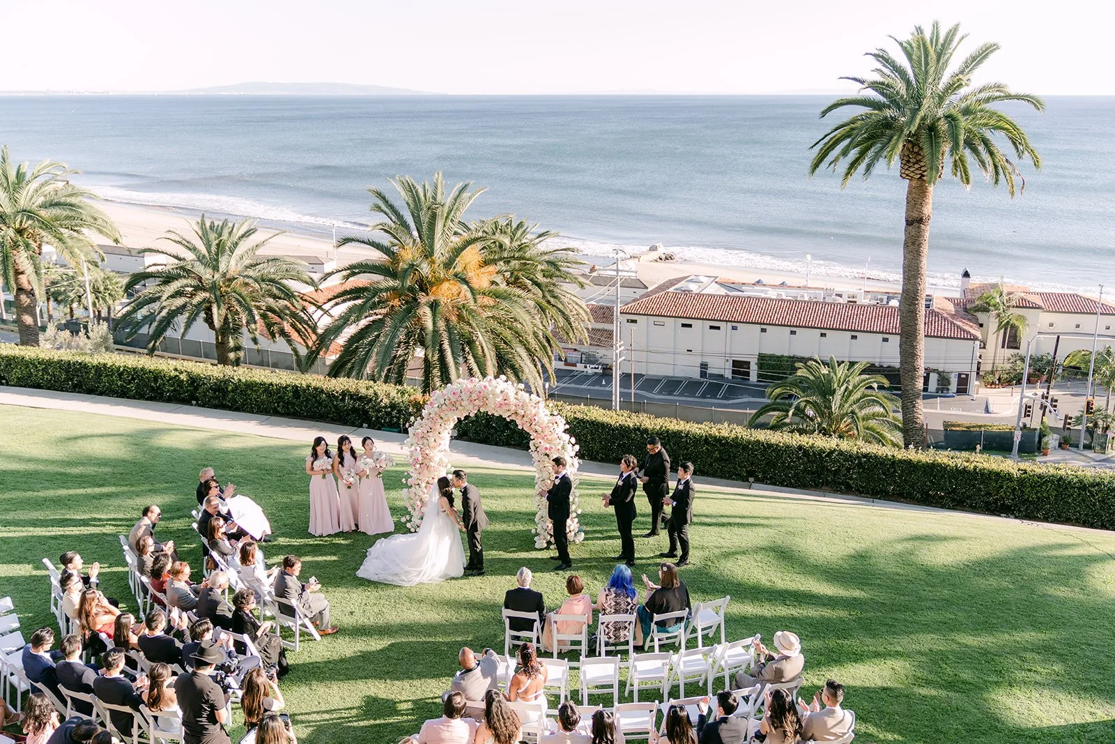 Wide view of the ceremony with the beach and ocean beyond