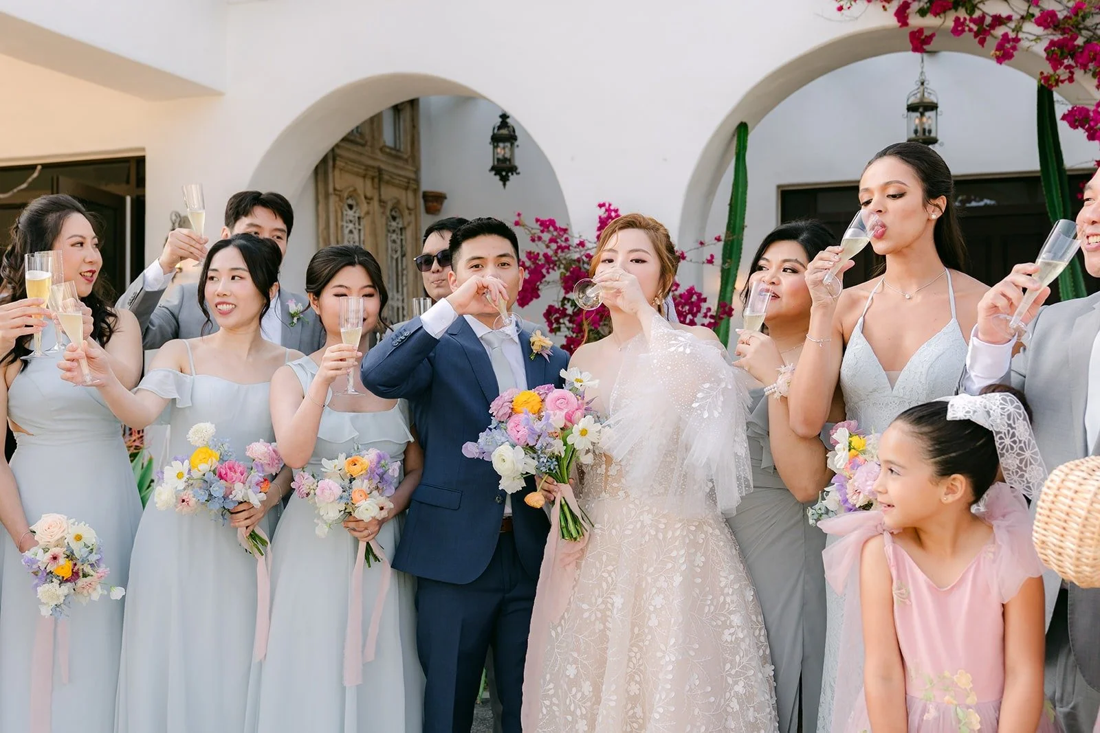 The wedding party and flower girls gathered close around Joanna and Jerrick, photographed by One and Only Production