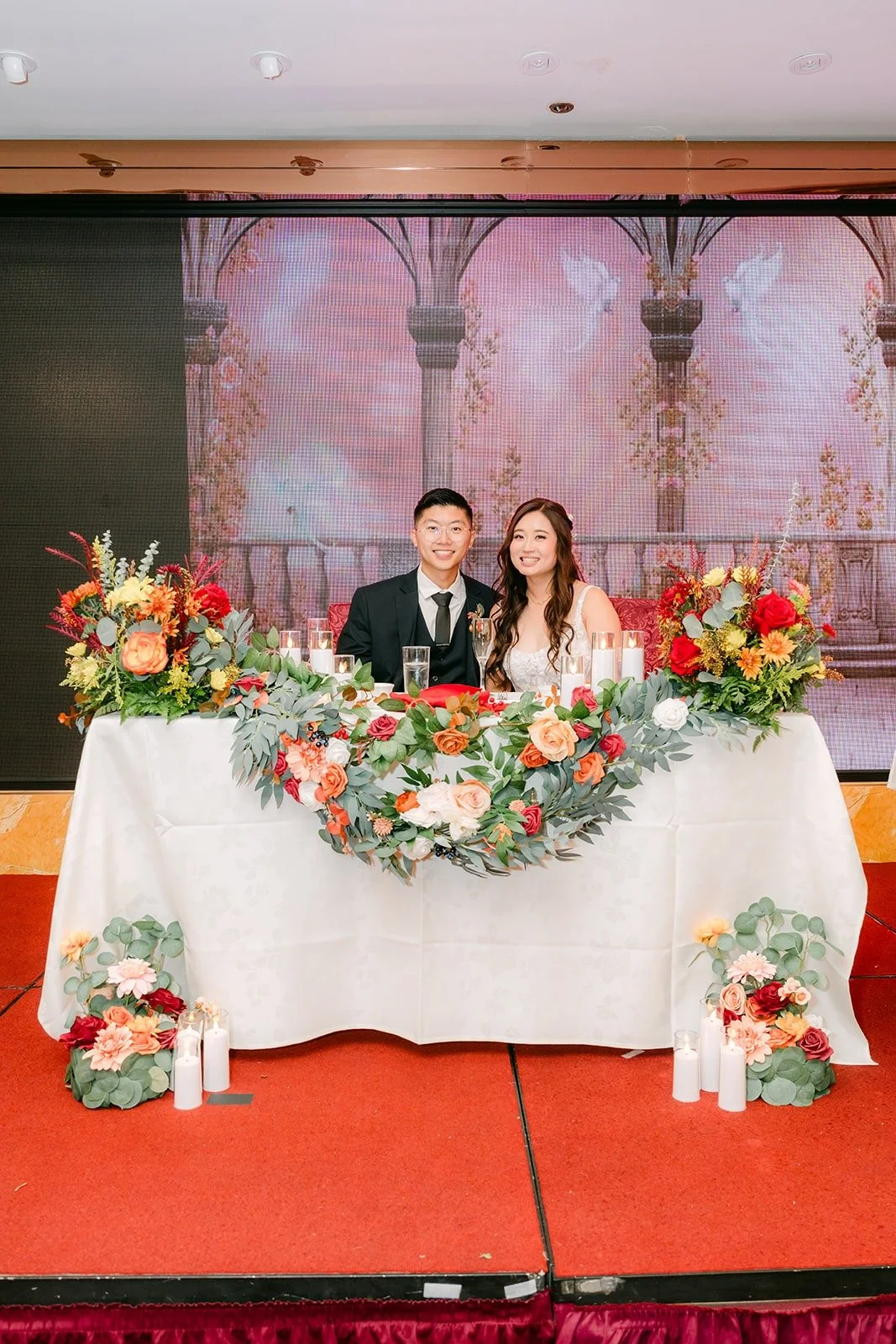 The sweetheart table with Shayna and Robert framed by florals