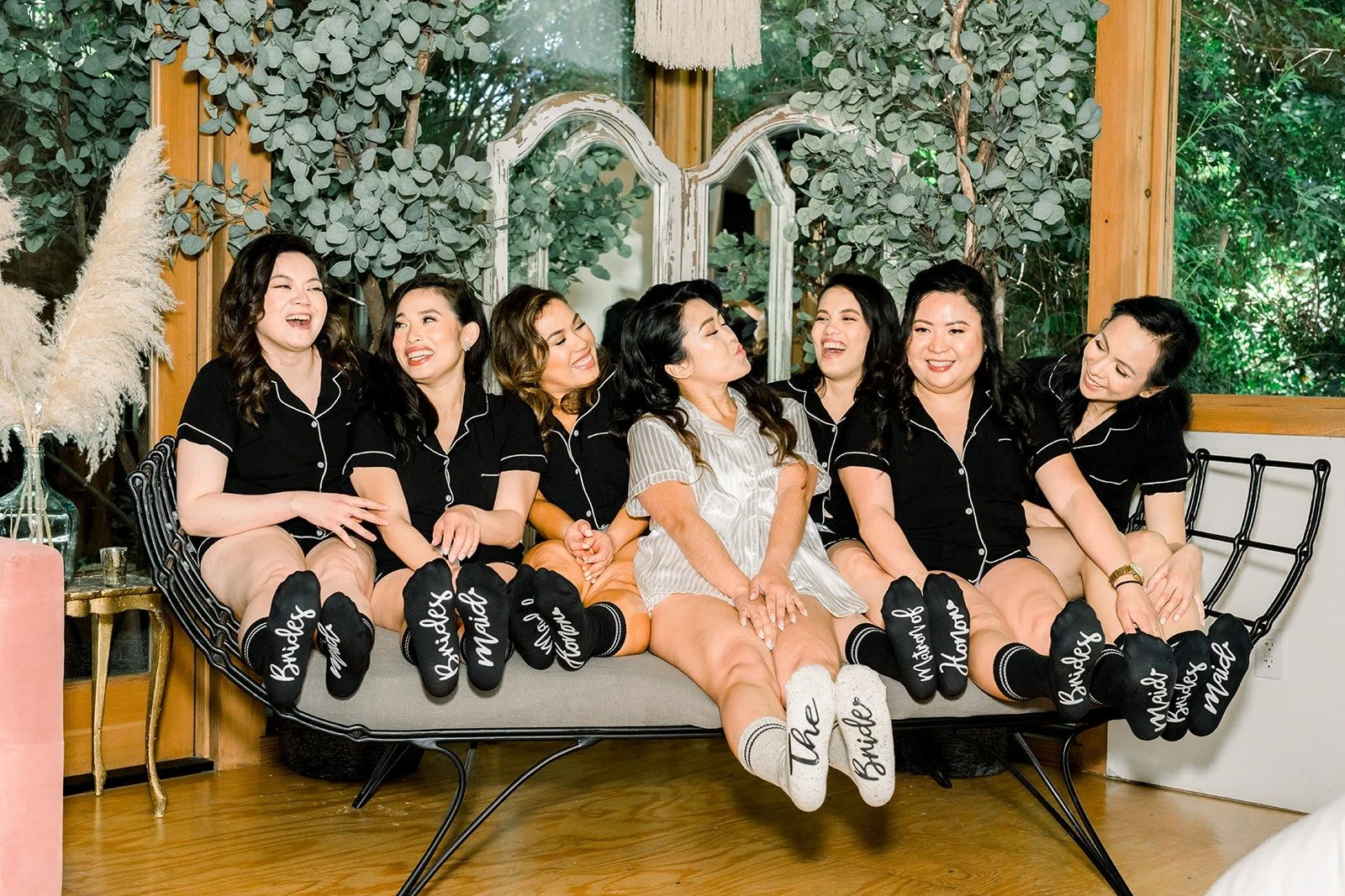 Hannah and her bridesmaids in black pajamas on the sofa