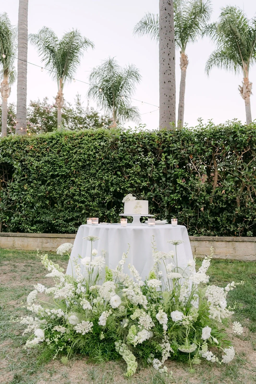 The cake table with white florals on the Adella Lawn