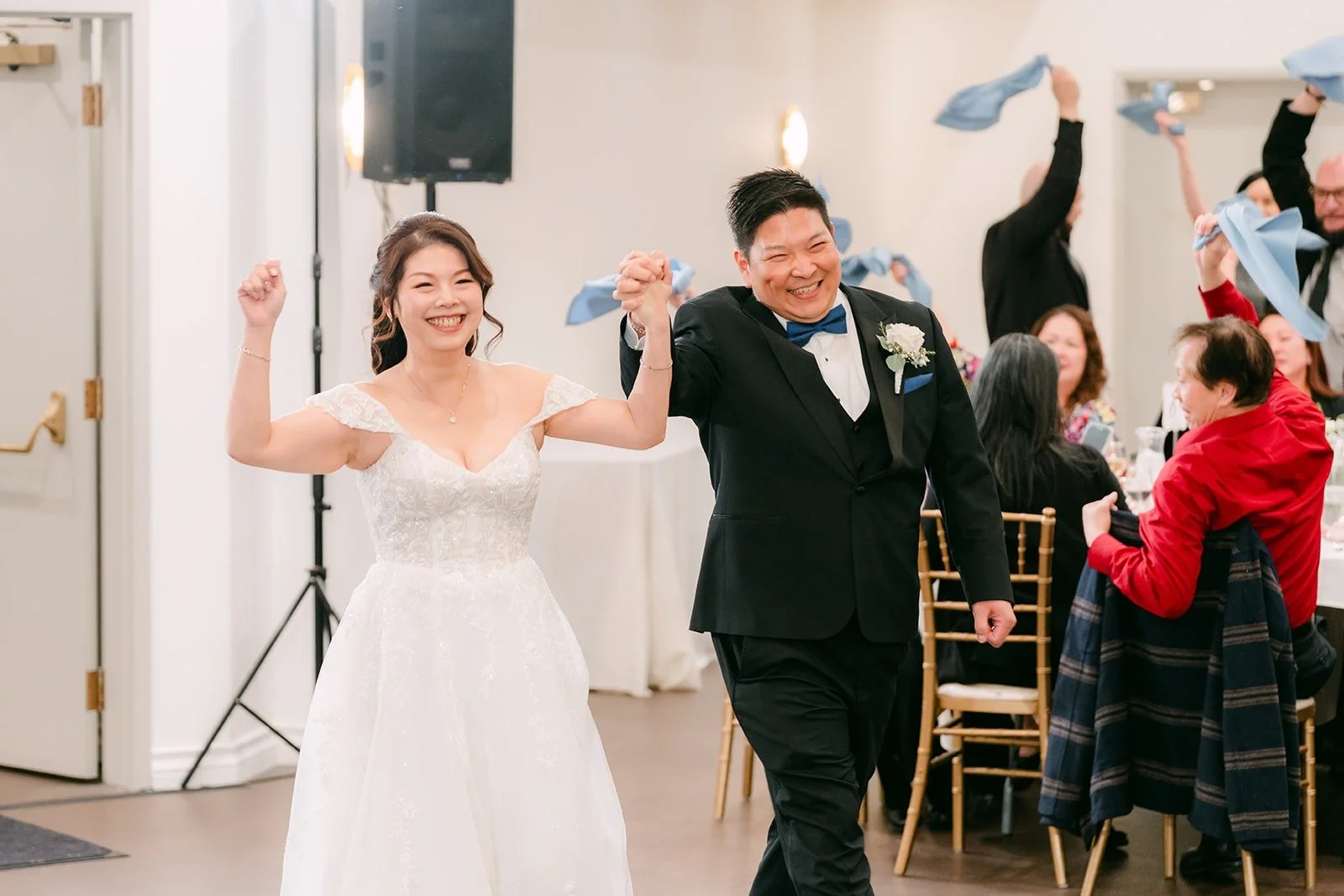 Sochi and Jay cheer as guests wave napkins for the grand entrance