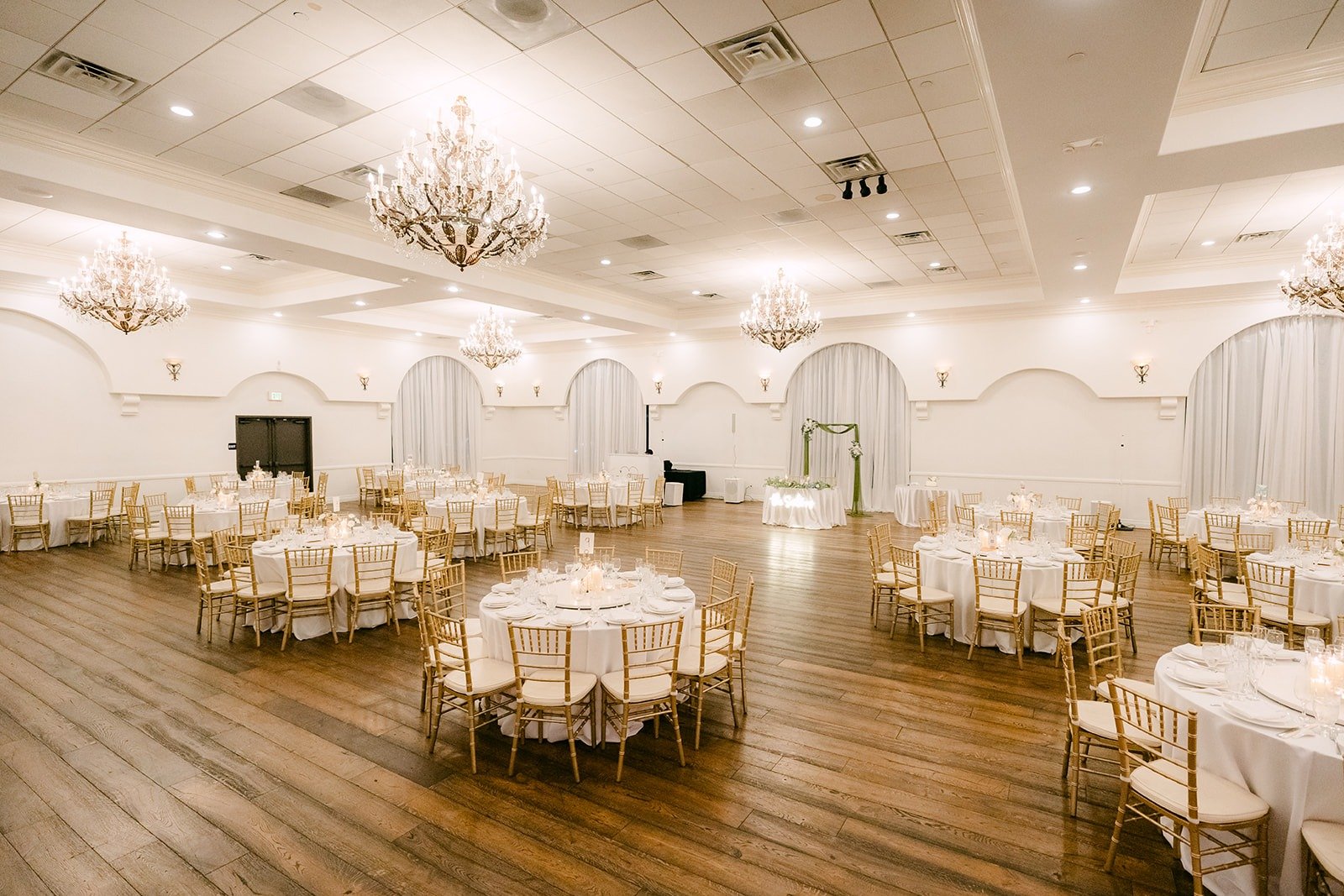 The ballroom at The Villa set with round tables and chandeliers
