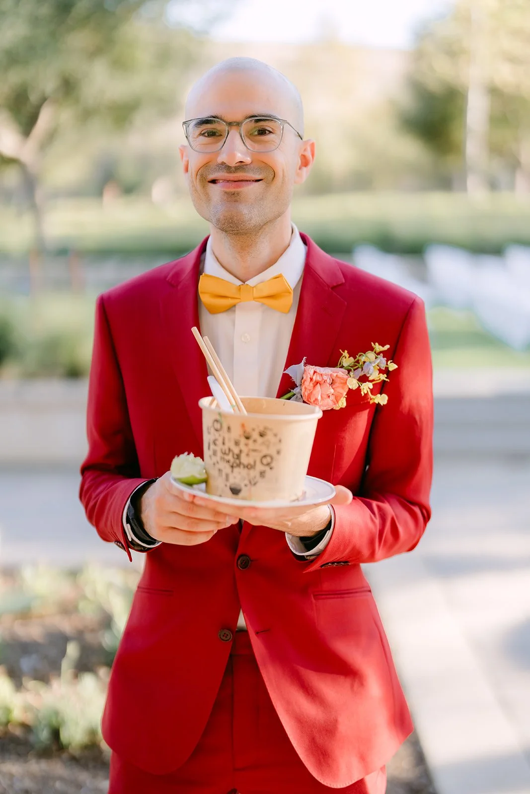 Christian smiling in his red suit with a boutonniere.