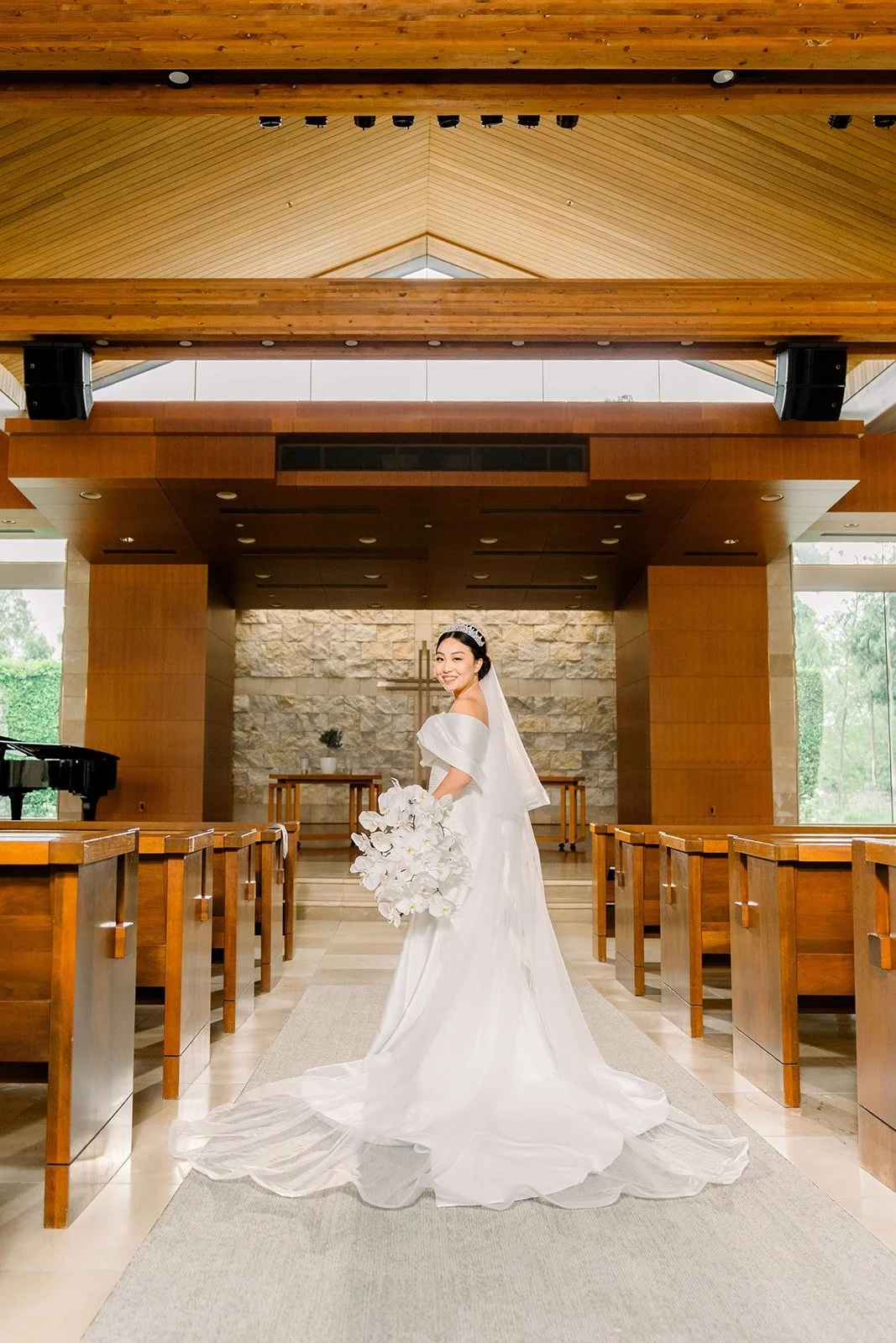 Jacinda in her gown and veil inside the wood paneled sanctuary at Crossline Community Church