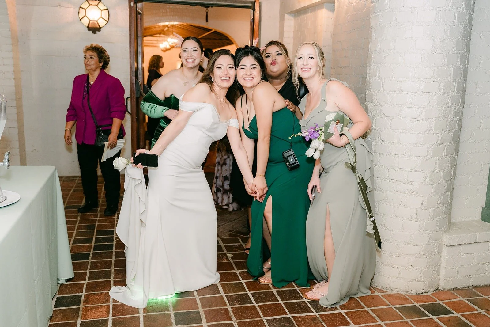 Mariana and her bridesmaids laughing before the exit