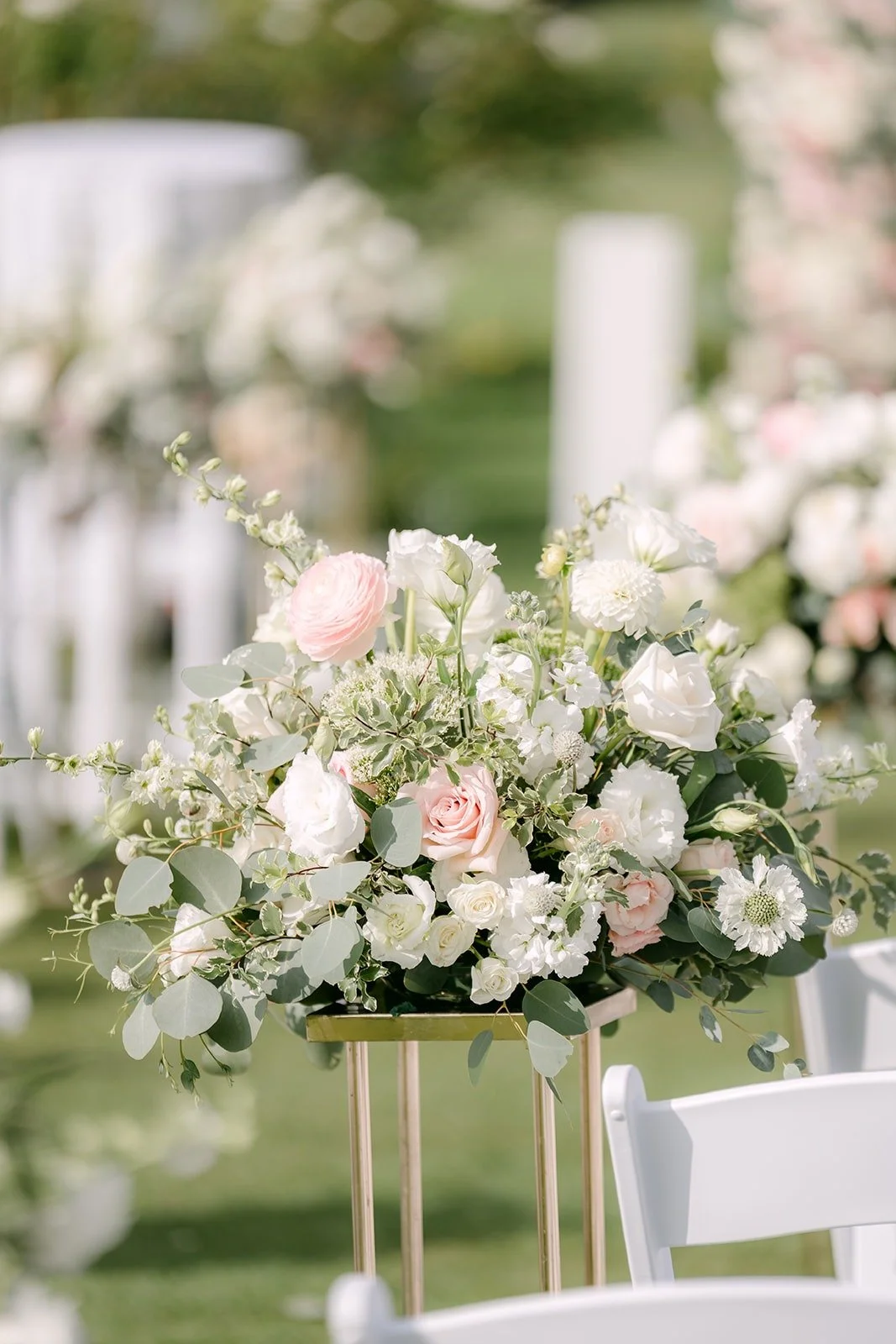 Blush and white roses on gold stands along the aisle