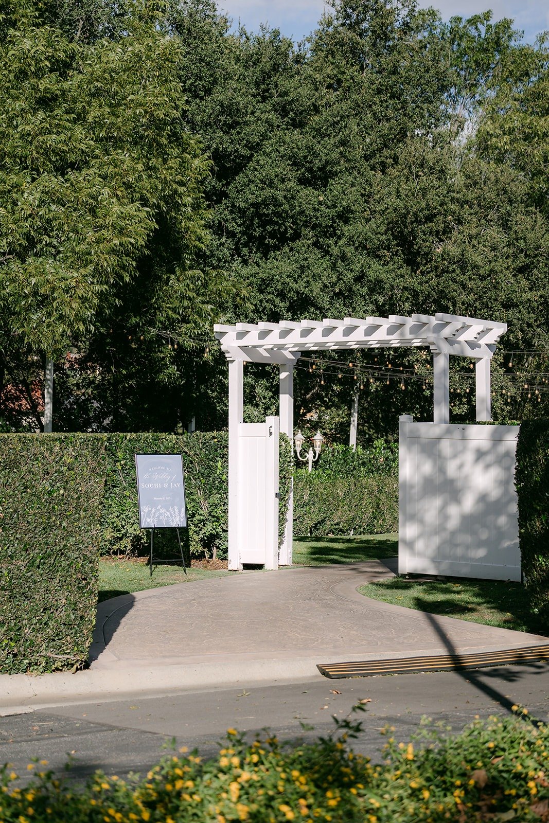 The white arbor and welcome signs at the ceremony garden at Sierra La Verne