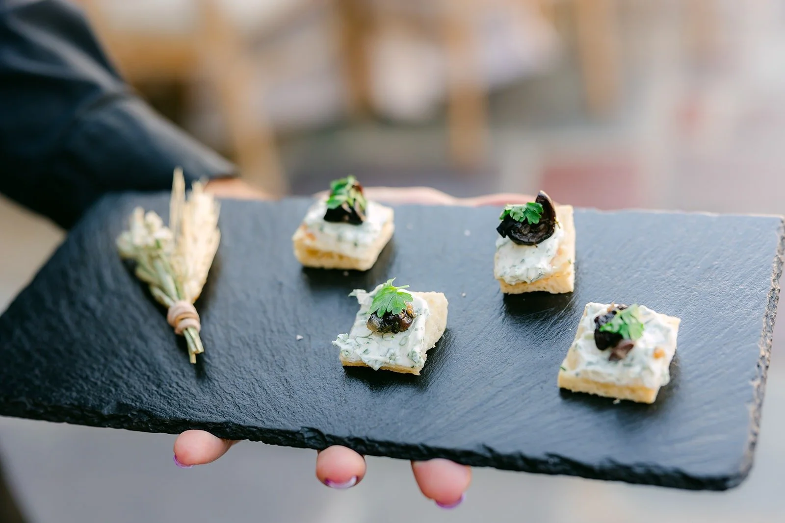 Passed appetizers on a slate tray during cocktail hour