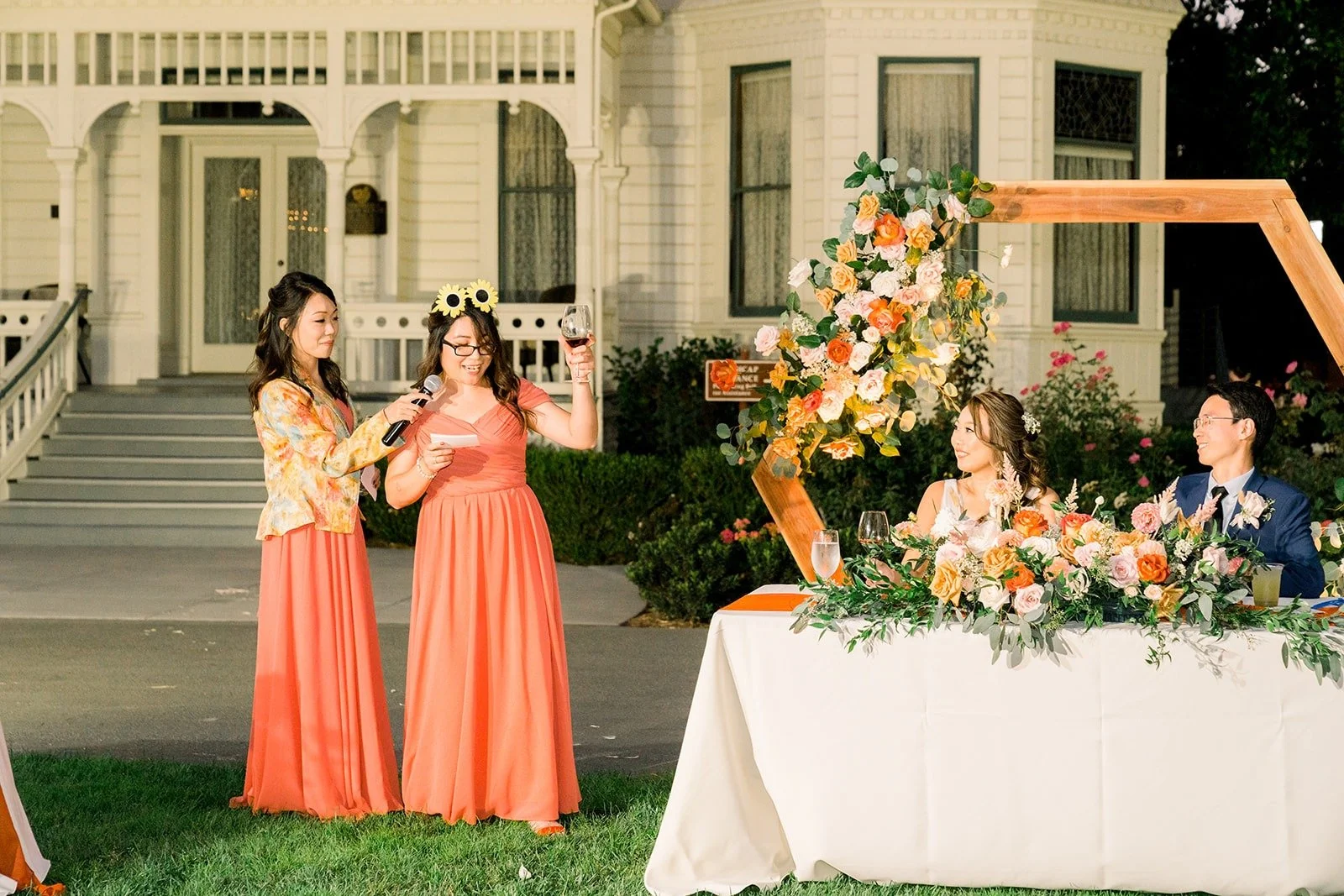 Bridesmaids in coral gathered for a speech