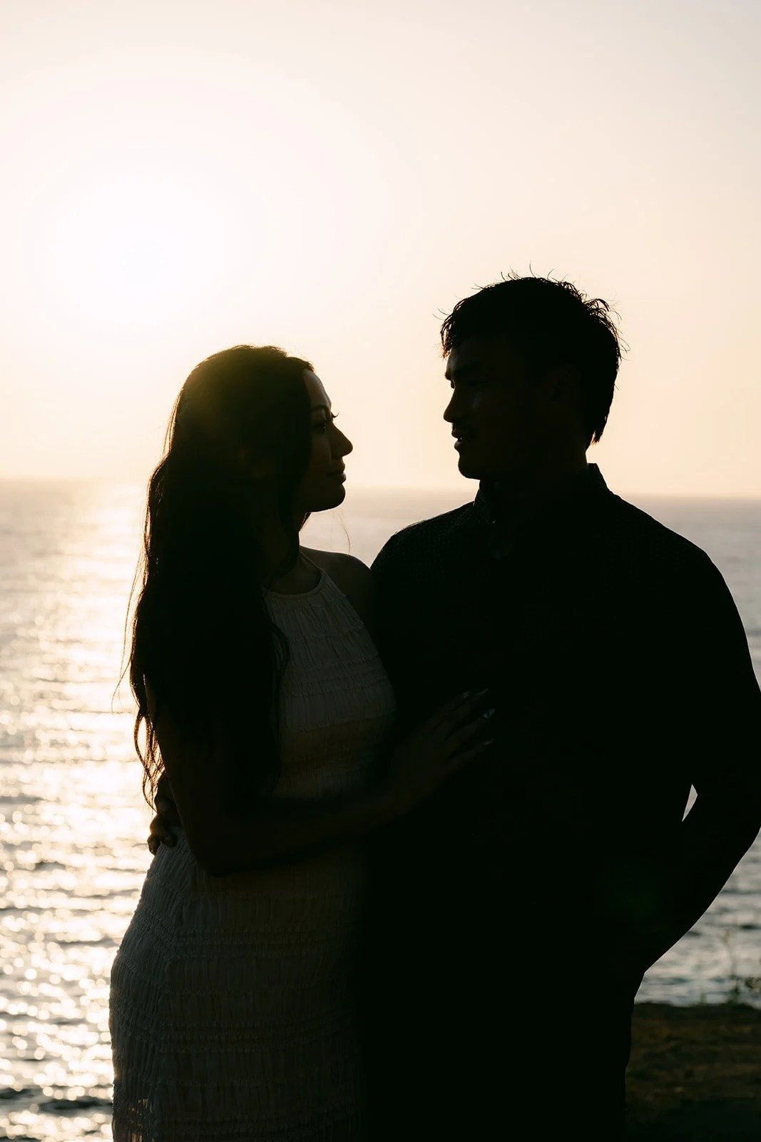 Silhouette of Victoria and Andrew against the sunset over the Palos Verdes coast, photographed by One and Only Production.