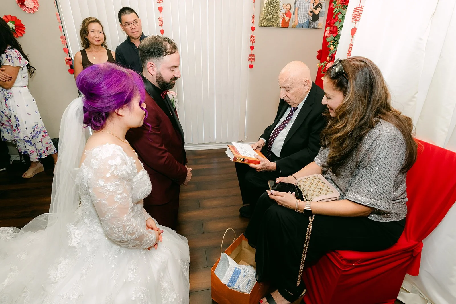 Vanessa and Ryan kneeling to serve tea to relatives.
