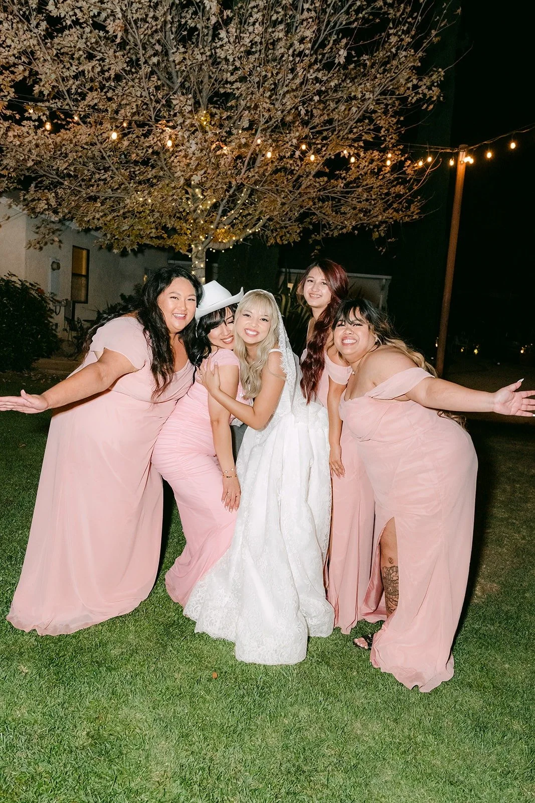 Konitha and her bridesmaids posing on the lawn at night