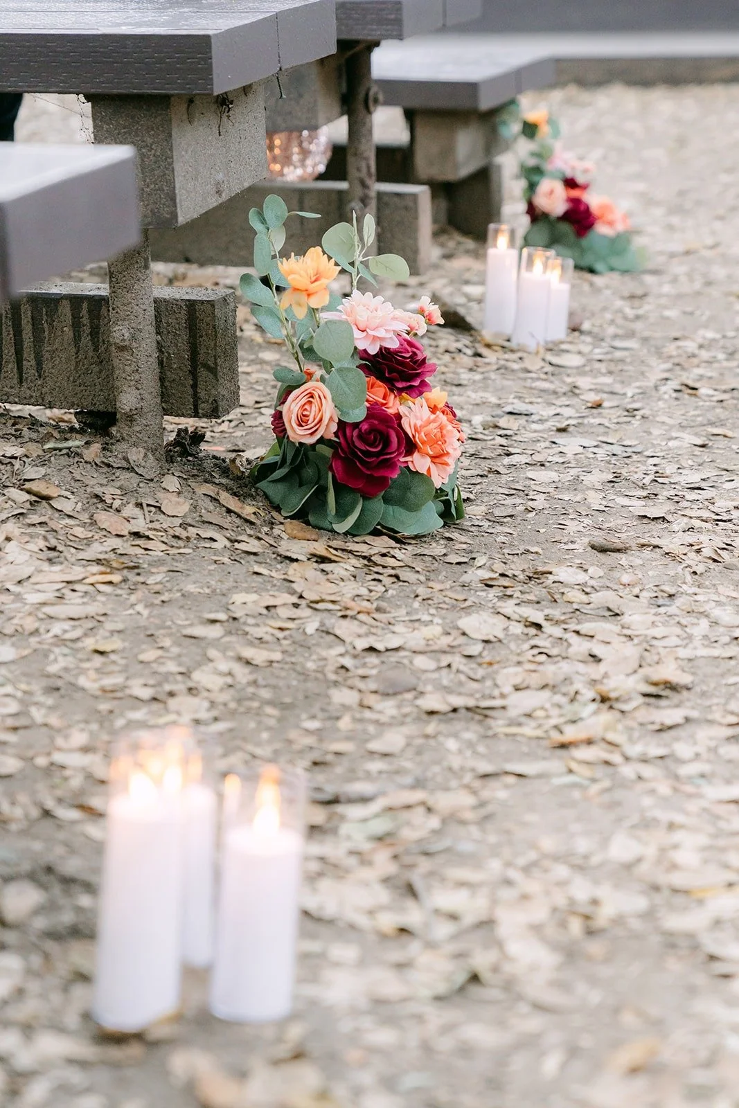 Candles and floral arrangements along the ceremony benches