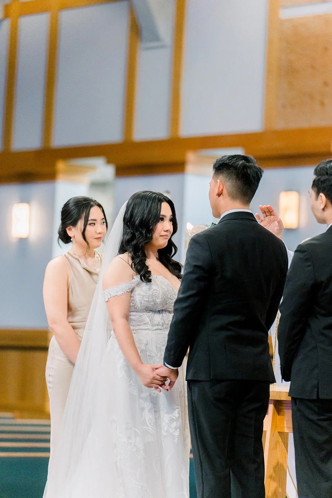 Francesca and Ralph holding hands at the altar with their wedding party