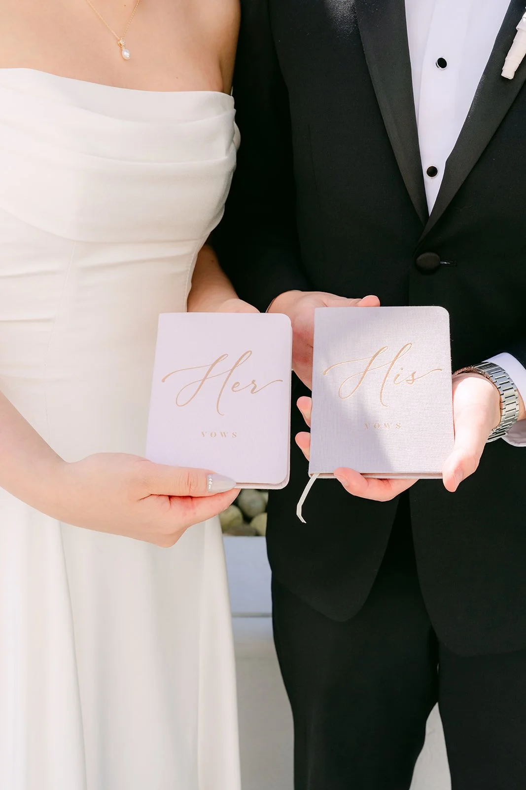 Amanda and San holding their His and Hers vow books.