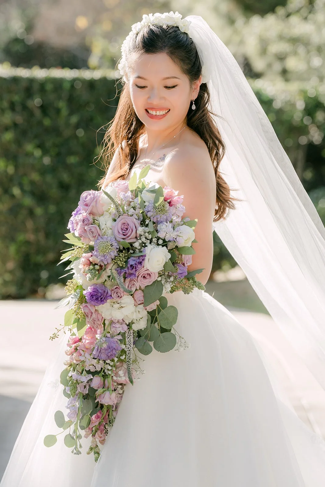 Kate smiling over her shoulder with her cascading bouquet.