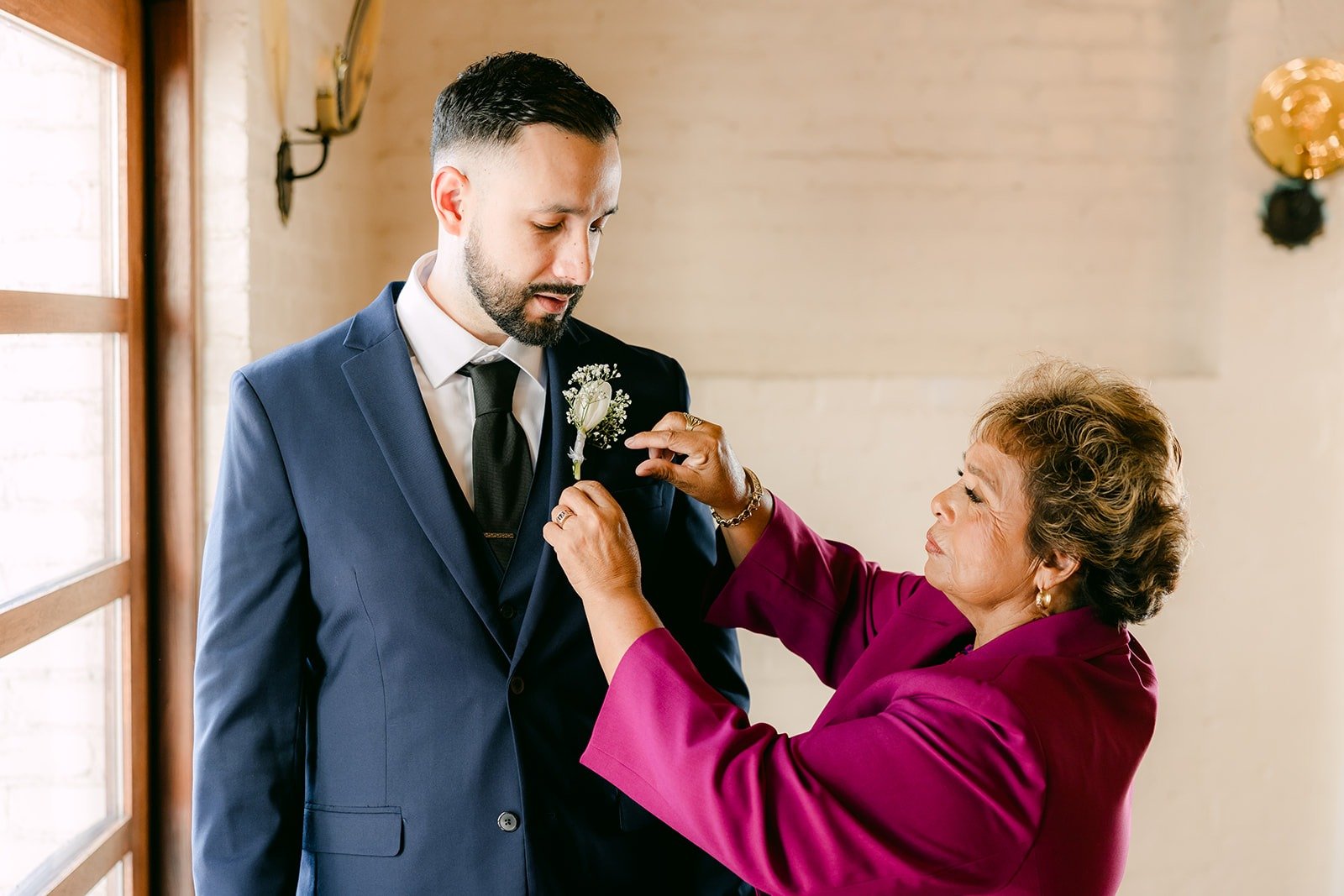 A family member pinning Danny's white boutonniere