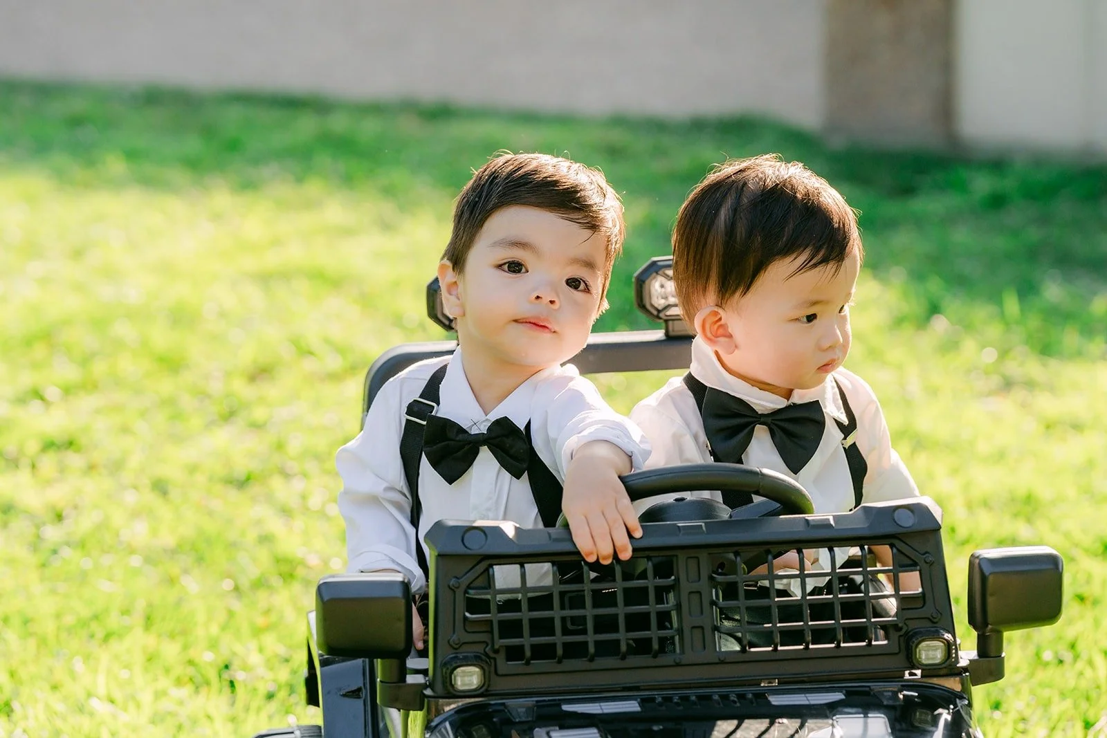 The ring bearers riding down the aisle in a toy car