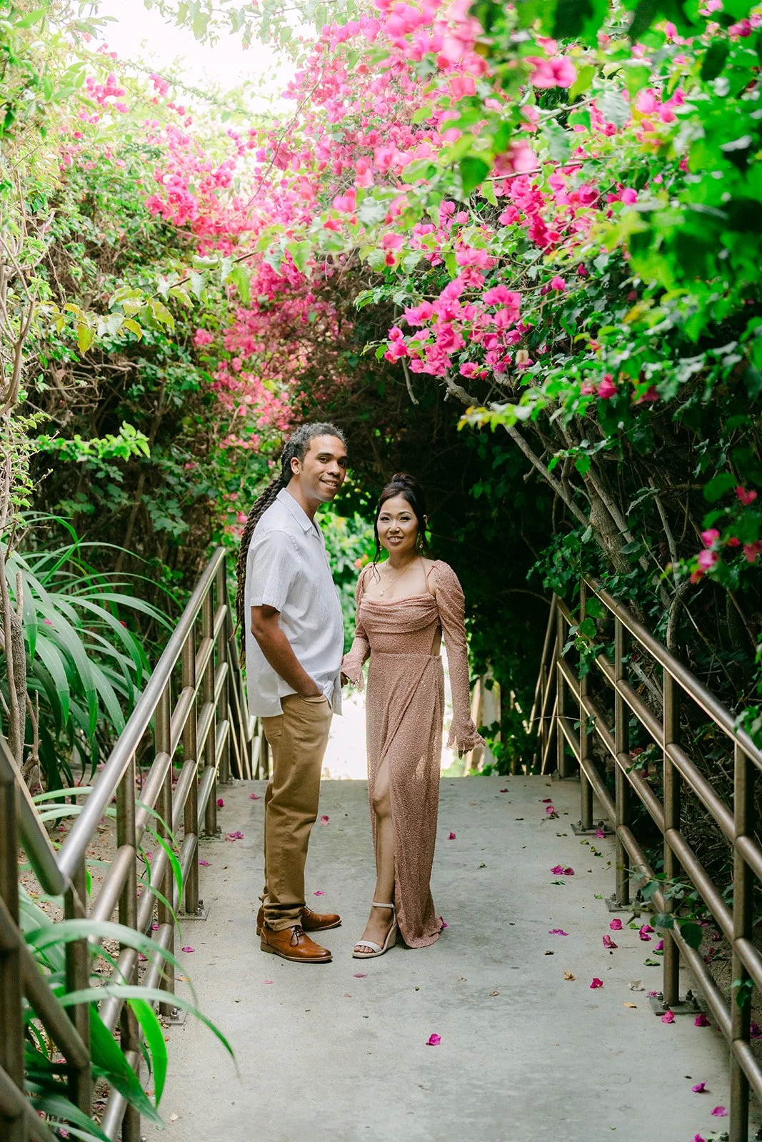 Amy and Michael on a stairway framed by pink flowers on the way to Table Rock Beach.