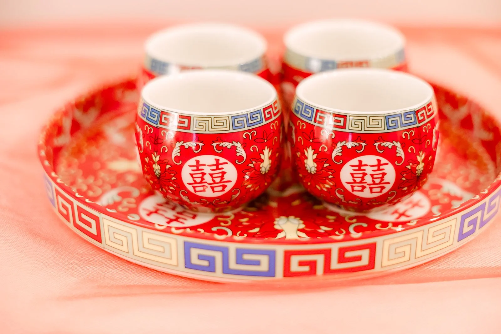 Three red teacups on a decorative tray for the tea ceremony.