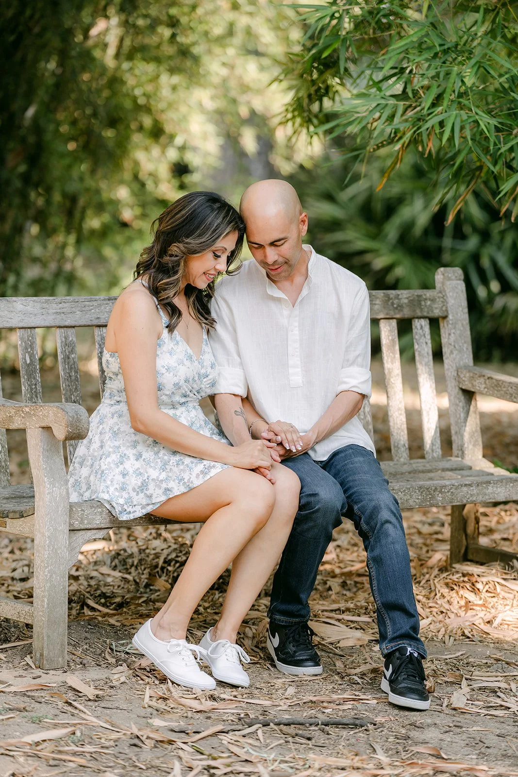 Francesca leans into Daniel as they sit on the garden bench.