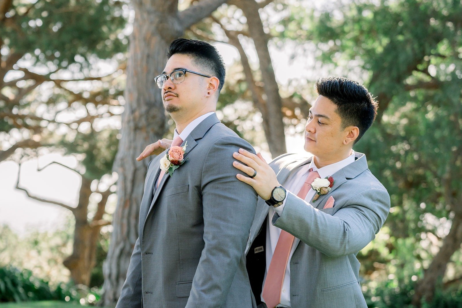 A groomsman straightens Mikey's tie